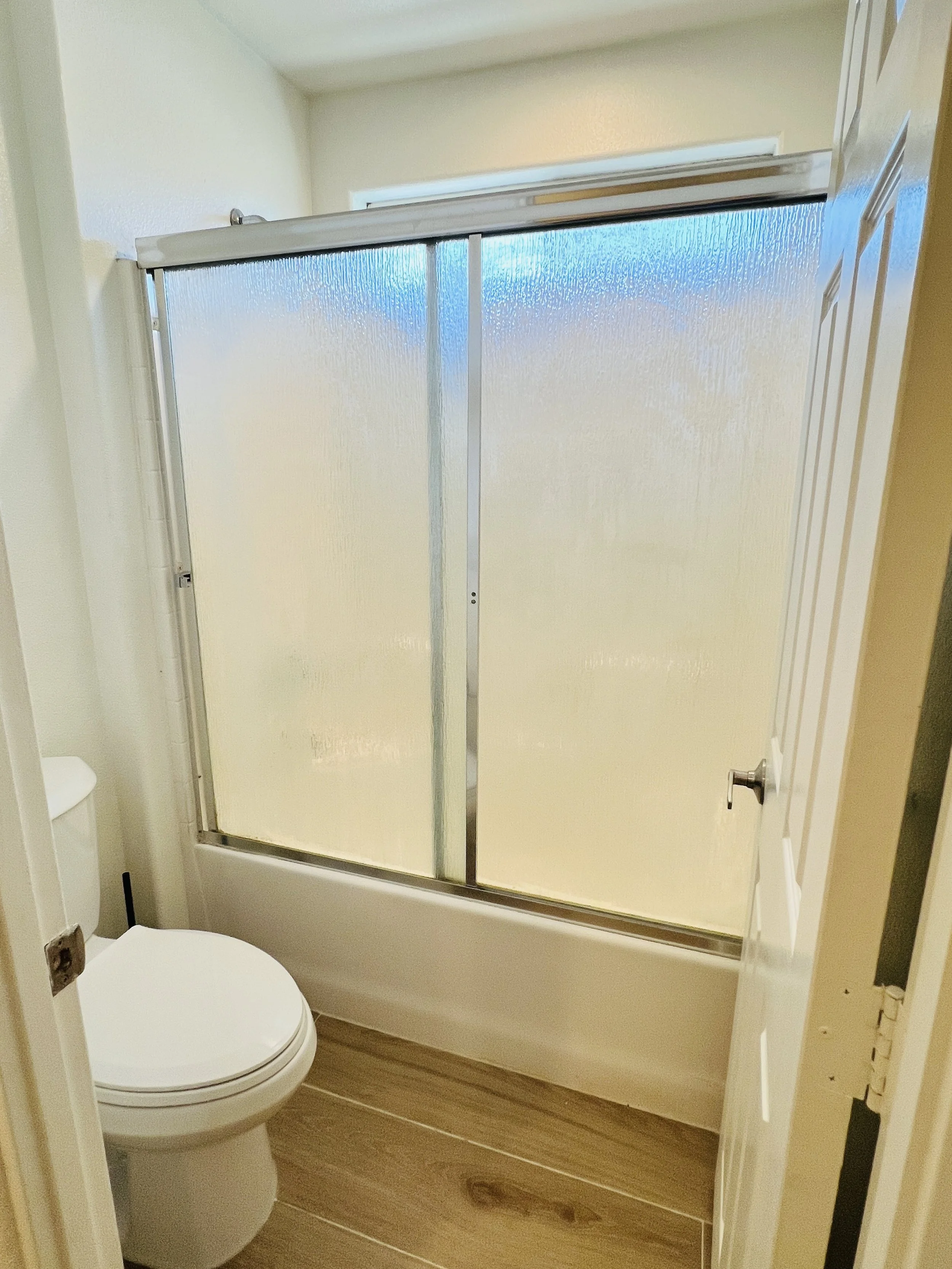 Bathroom with a frosted glass shower enclosure and a white toilet.