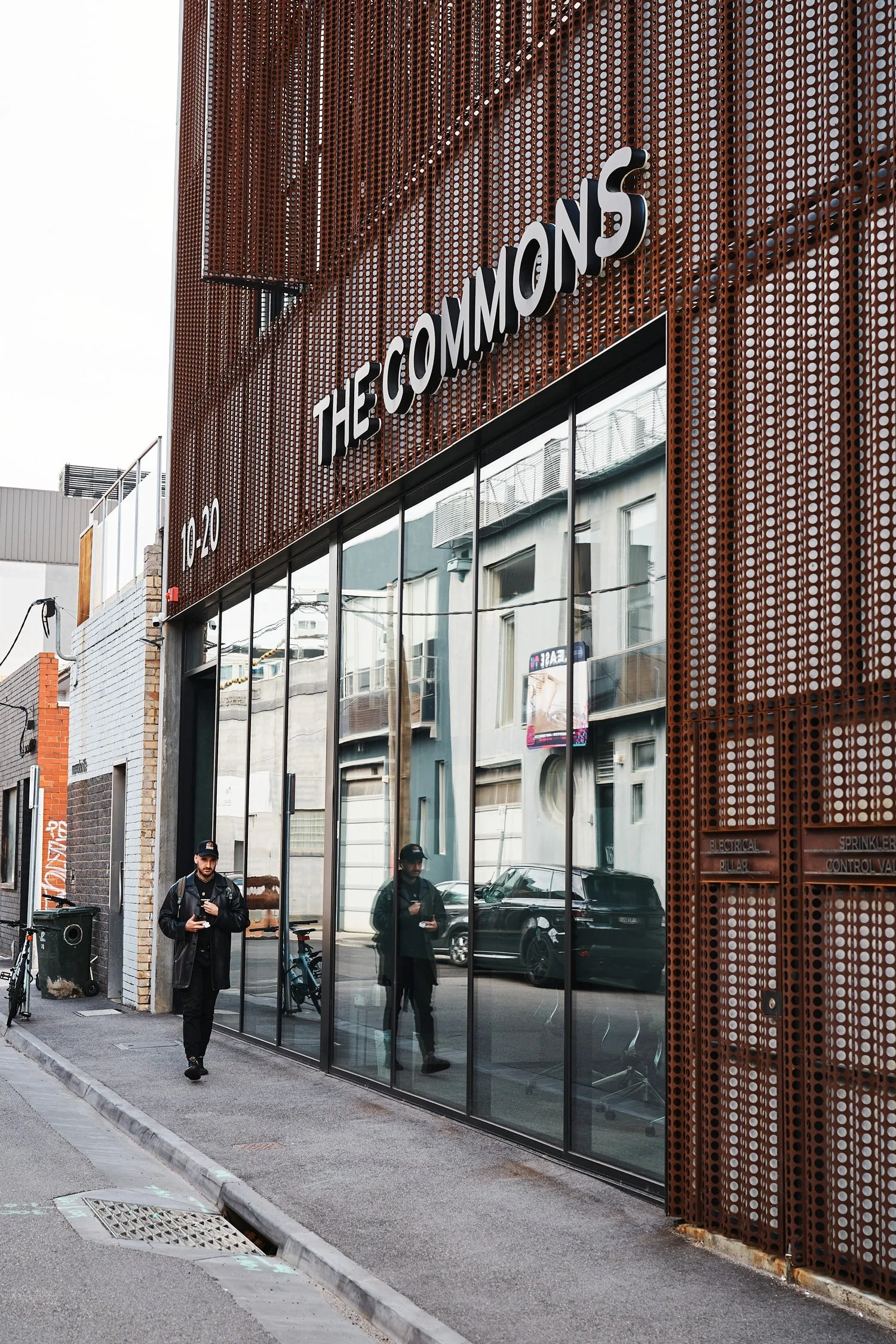 Street view of a The Commons, Cremorne with large glass windows, metal exterior with circular patterns.