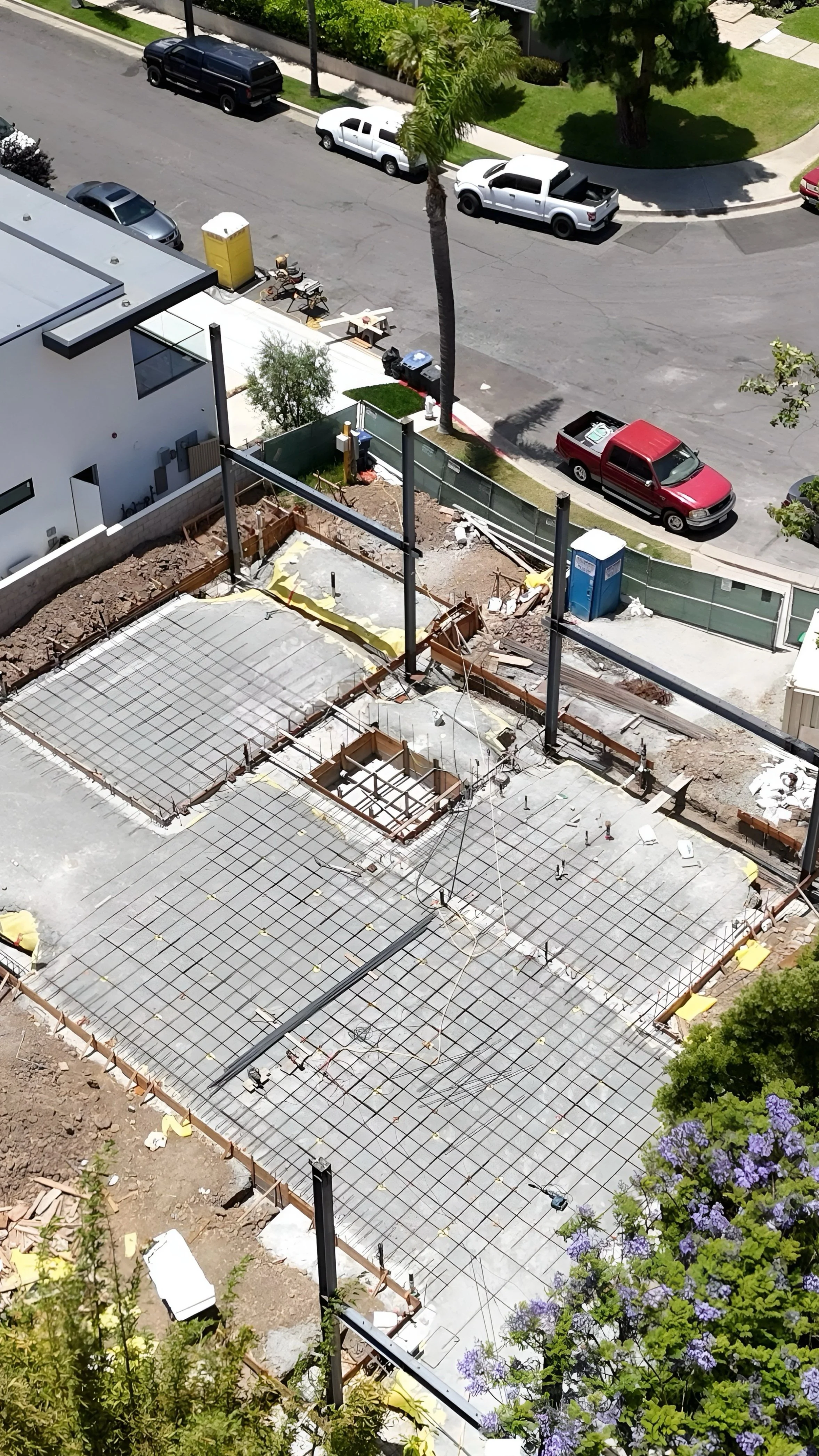 Construction site in the early stages of building a structure on a foundation with rebar framework.