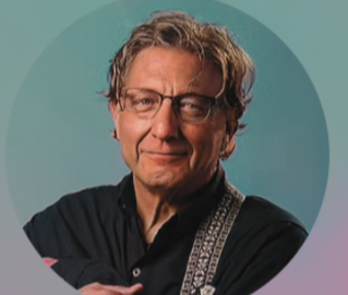 Black and white photo of a middle-aged man with wavy hair, glasses, and a slight smile, holding a guitar across his chest.