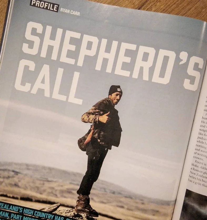 Magazine article featuring a man with a backpack standing outdoors in a rugged landscape, smiling and giving a thumbs-up, with the headline 'SHEPHERD'S CALL' and the subheader 'PROFILE RYAN CARR'.