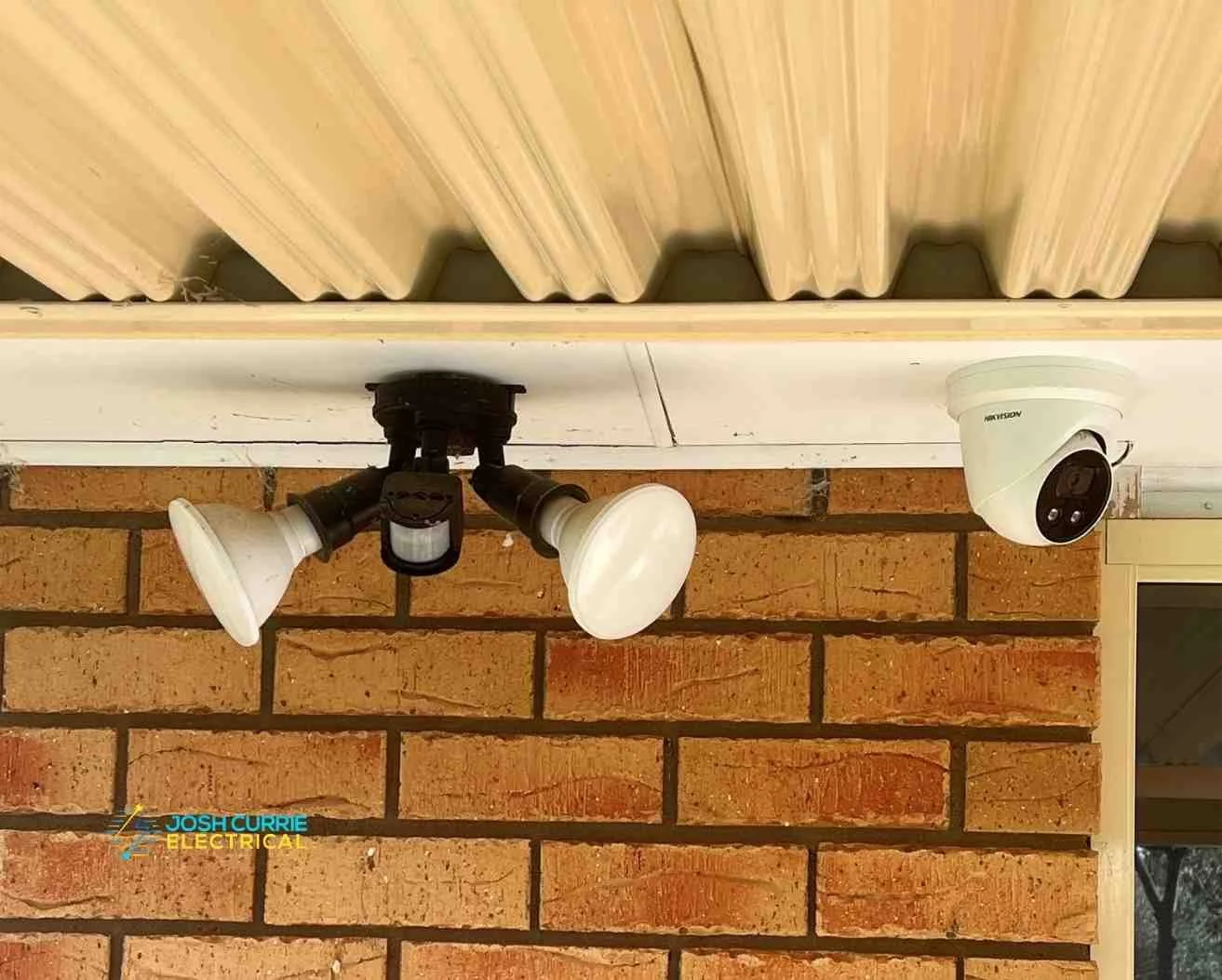 security lights and camers mounted on roof on red brick background