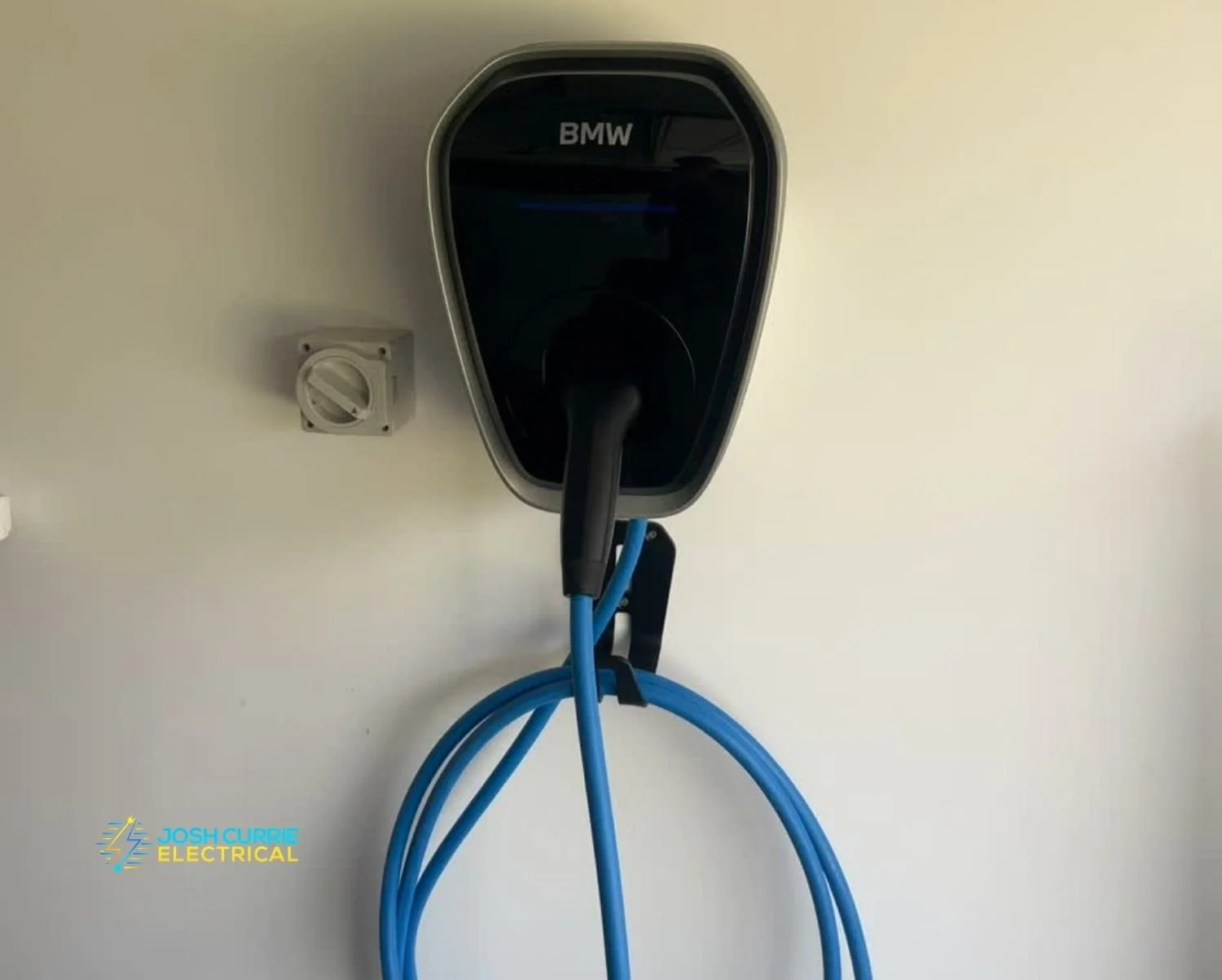 BMW EV charger installed in home garage Wagga black unit with blue cord