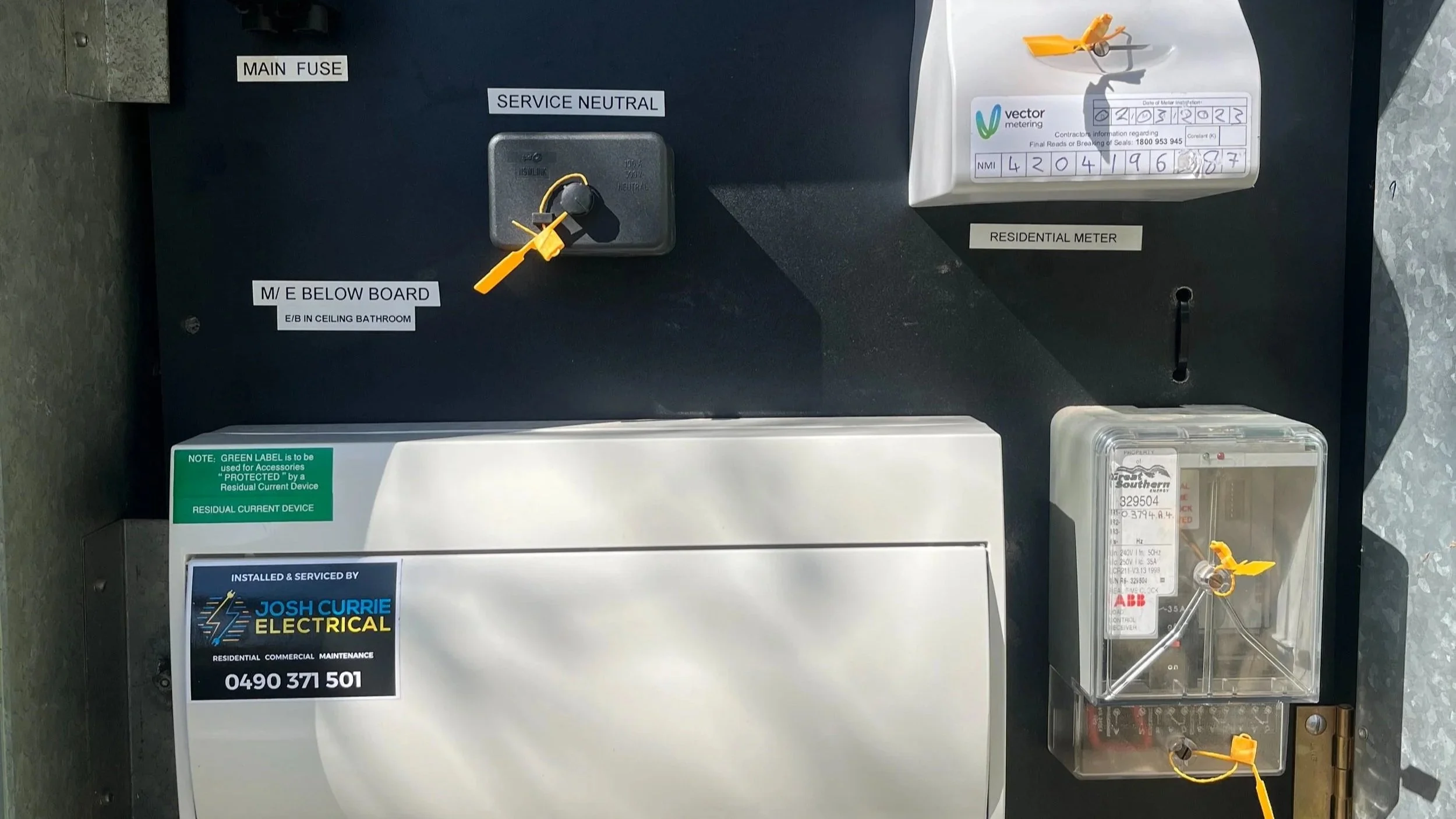 An electrical meter box and related components for monitoring utility usage, with labels indicating main fuse and service neutral, along with a residual current device and contactor information.