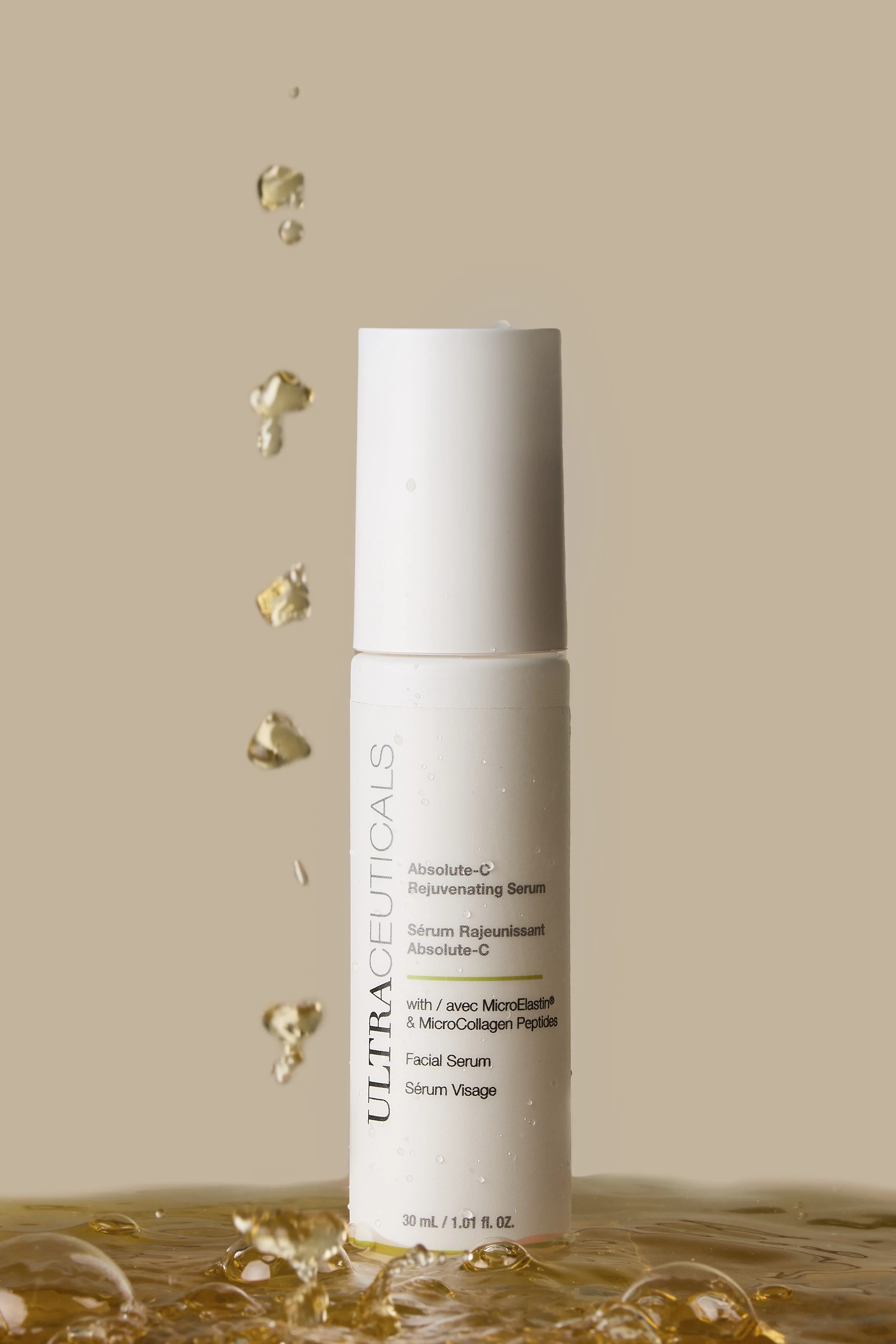 A white bottle of UlTRACEUTICALS Absolute-C Rejuvenating Serum stands upright on a surface with water and ice around it. Water droplets are visible on the bottle, and liquid is splashing around the base of the bottle against a beige background.