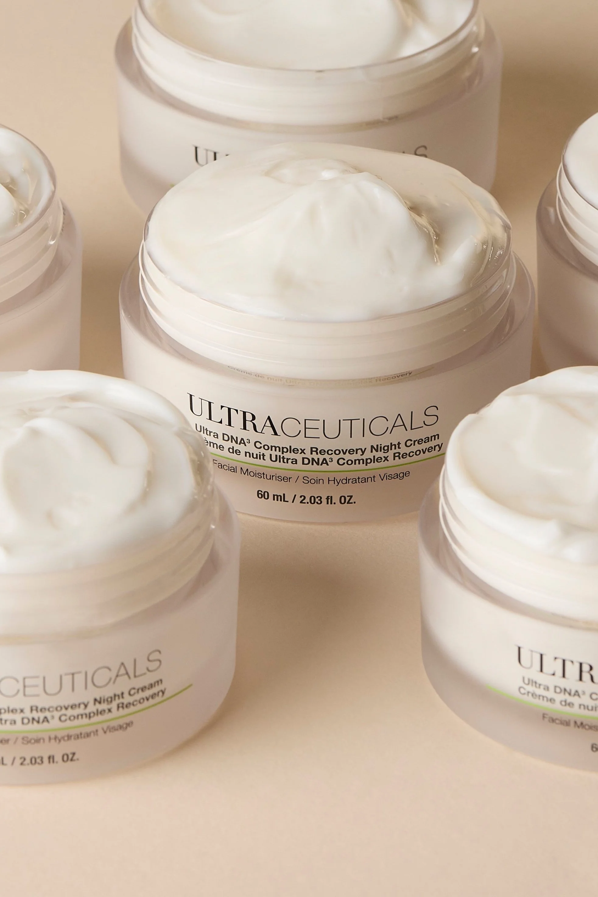 Multiple open jars of Ultraceuticals Ultra DNA Complex Recovery Night Cream with white cream inside.