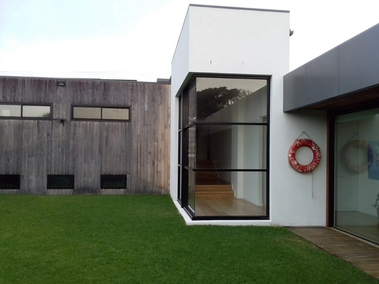 Glass atrium in modern timber cladded home