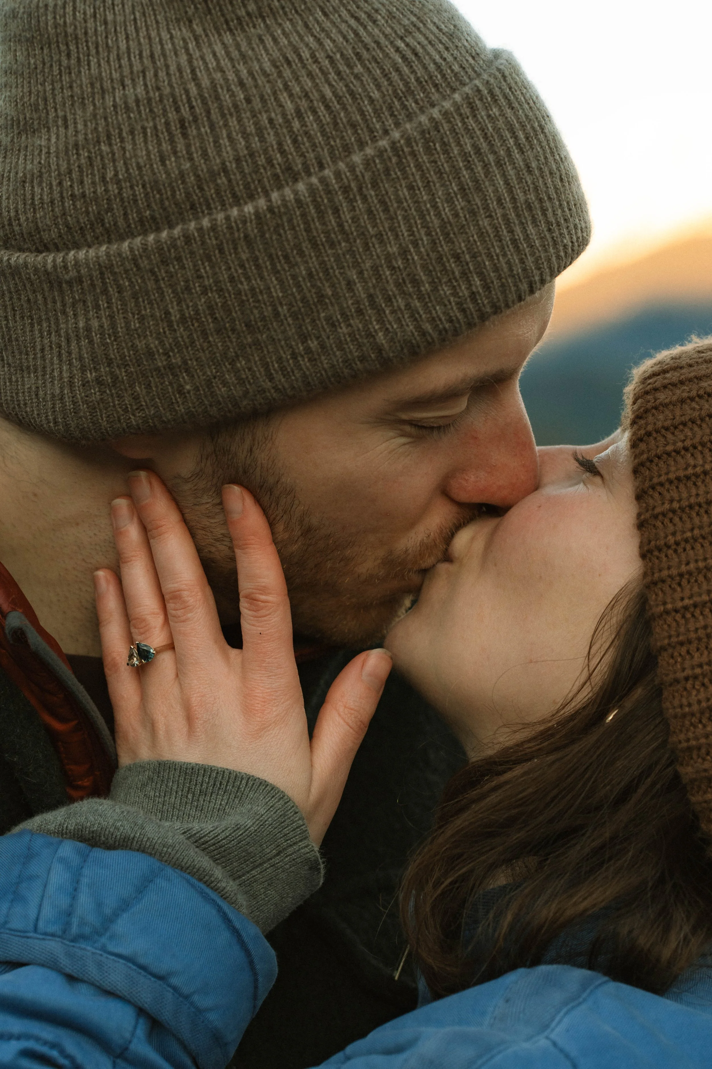 A man and a woman gently touching foreheads and noses, with their eyes closed, sharing an intimate moment.