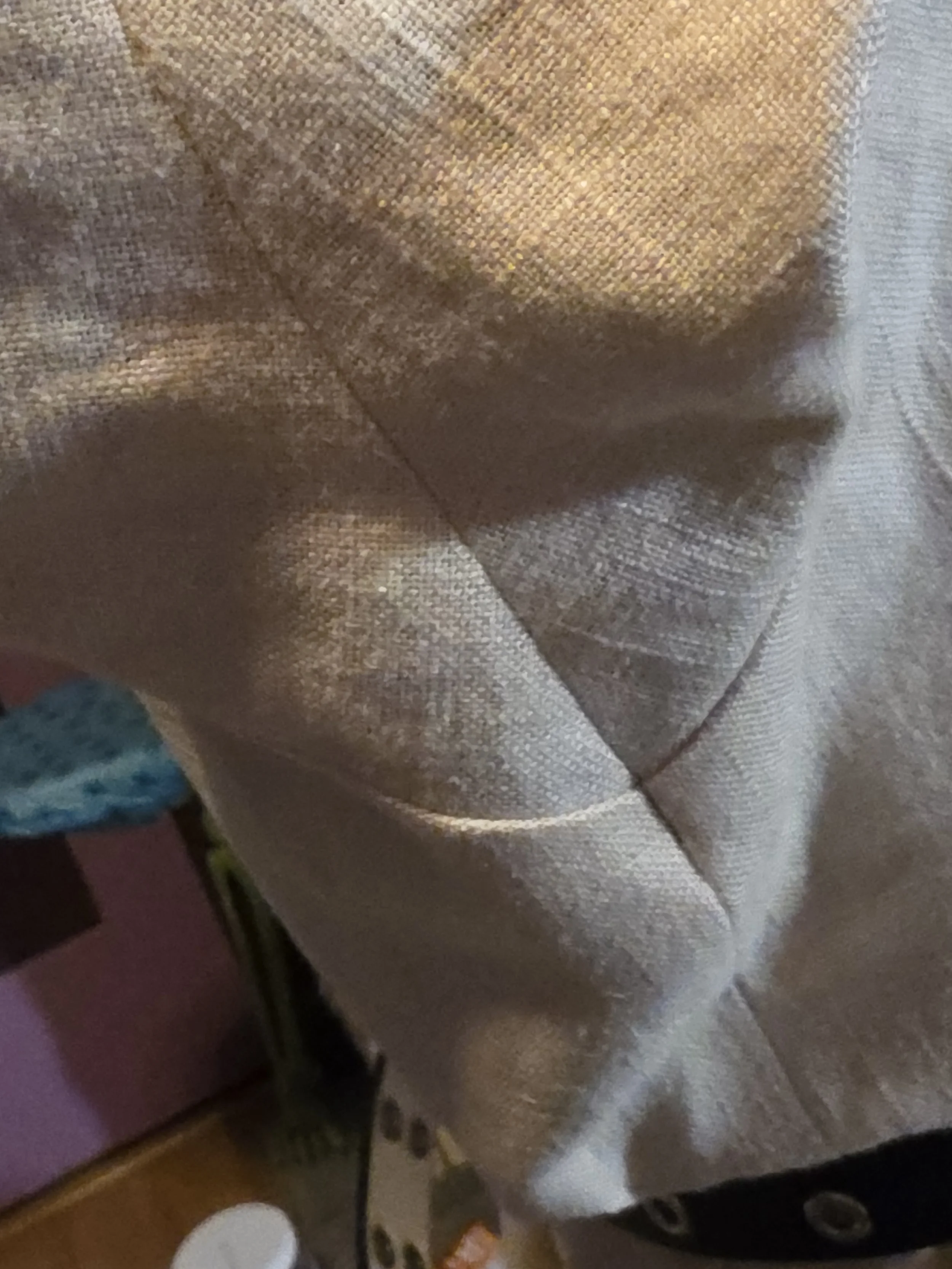 closeup of blessed seams in the underarm of an offwhite linen tunic. 2 seams cross over and are precisely matched at the point where they cross