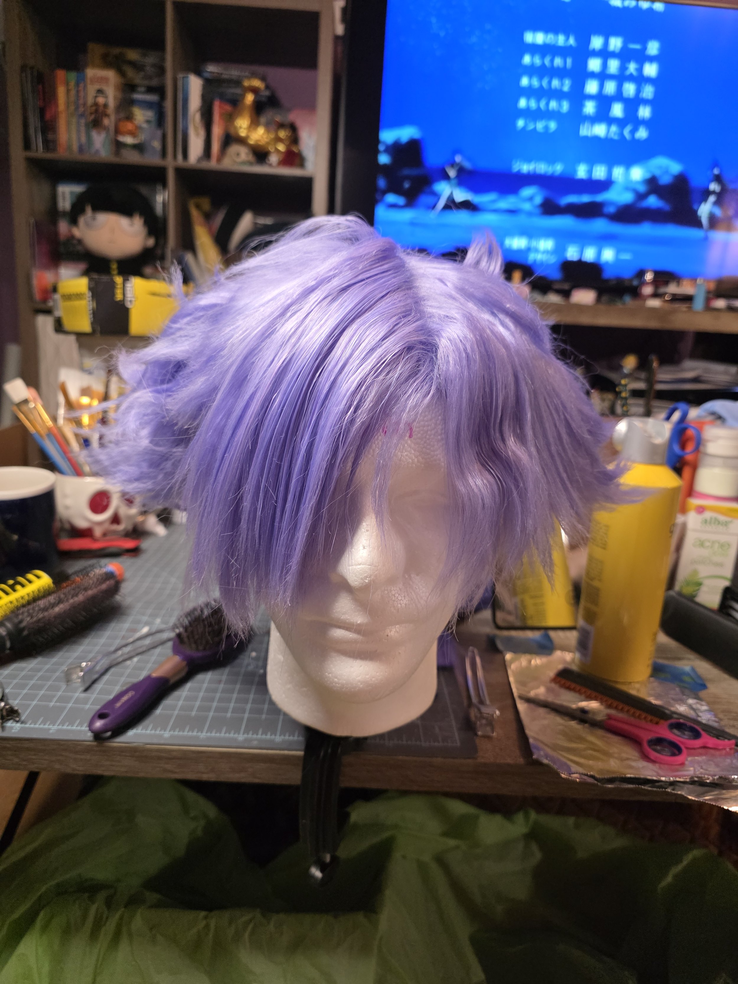 short lavender wig with long bangs combed over one eye. the sides are spiked outwards