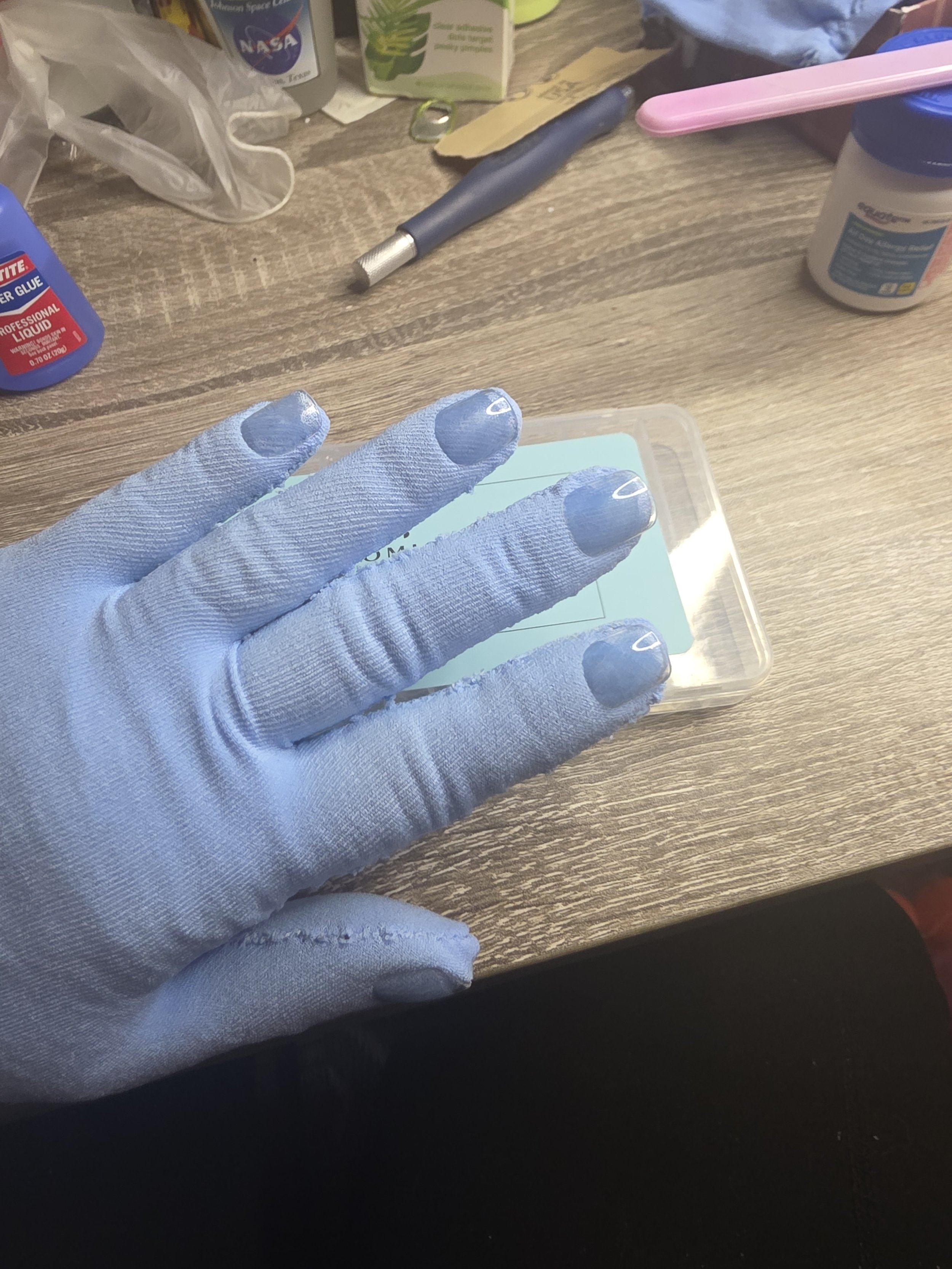 hand in a glove made of pale blue tights. It has a smooth, snug fit, and clear acrylic nails glued on