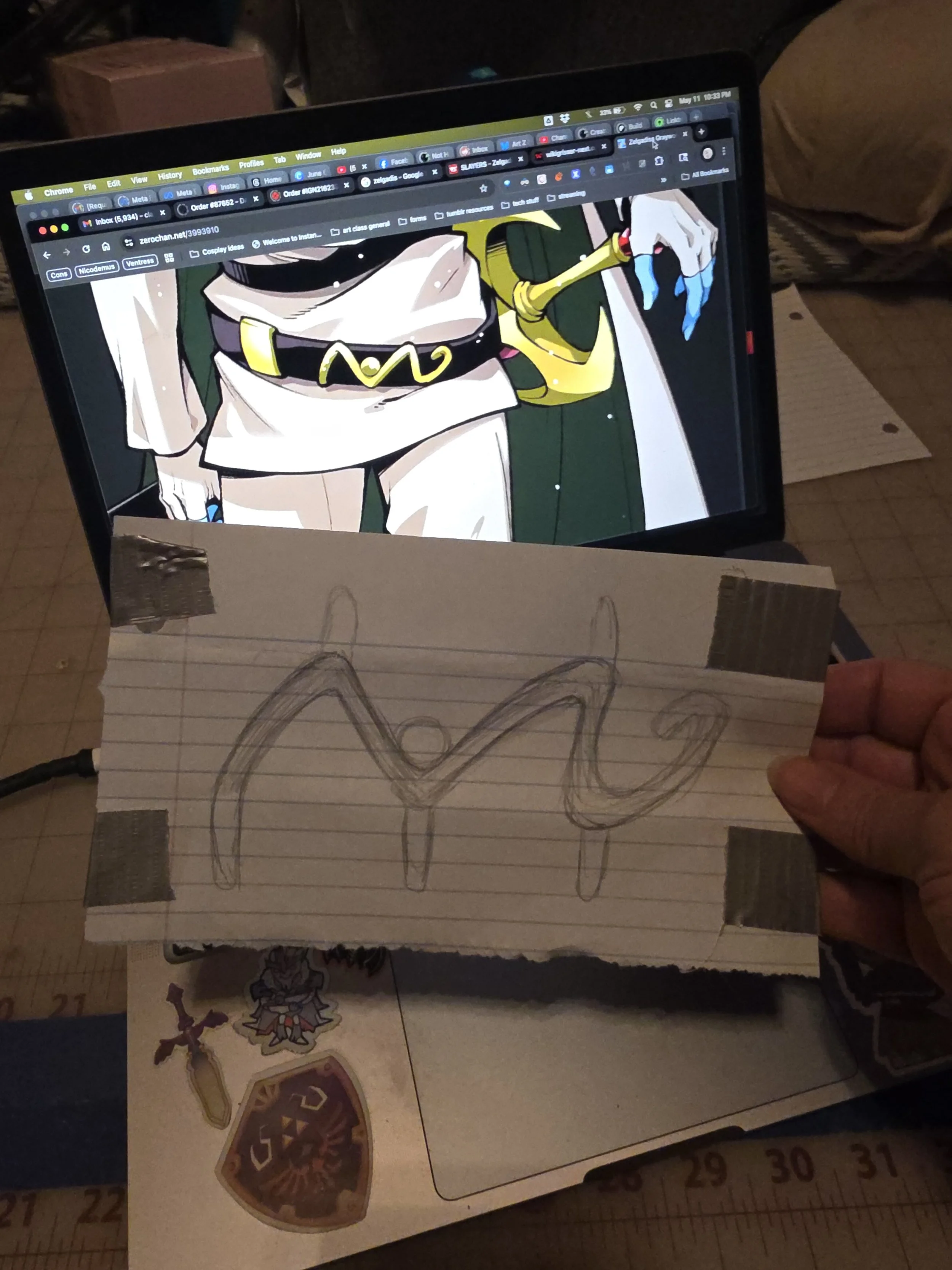 sketch of a squiggly shape, next to an image of Zelgadis's sword belts, showing a gold decoration of the same shape.
