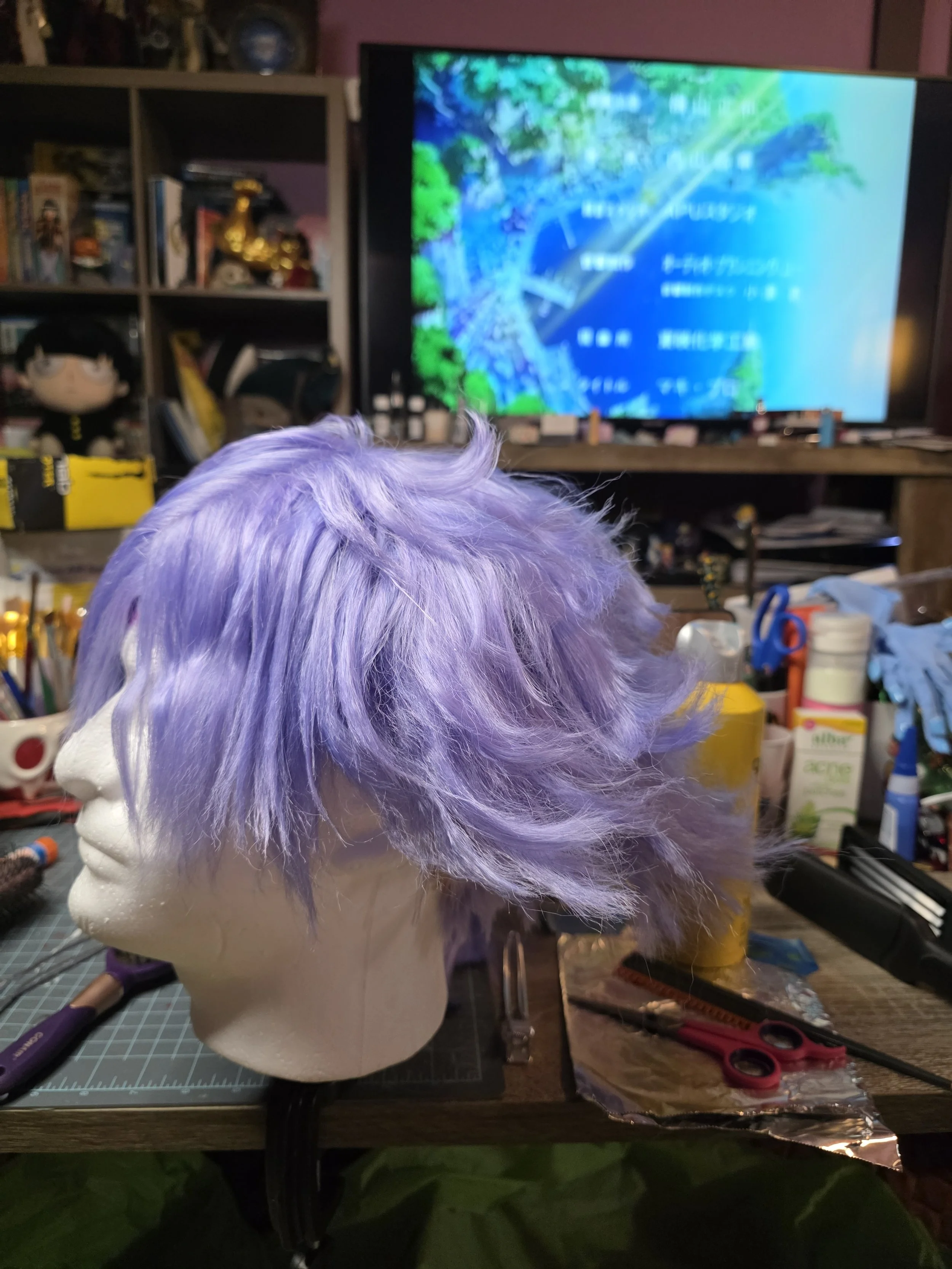 lavender wig with long bangs combed over one eye.  the back is spiked outwards