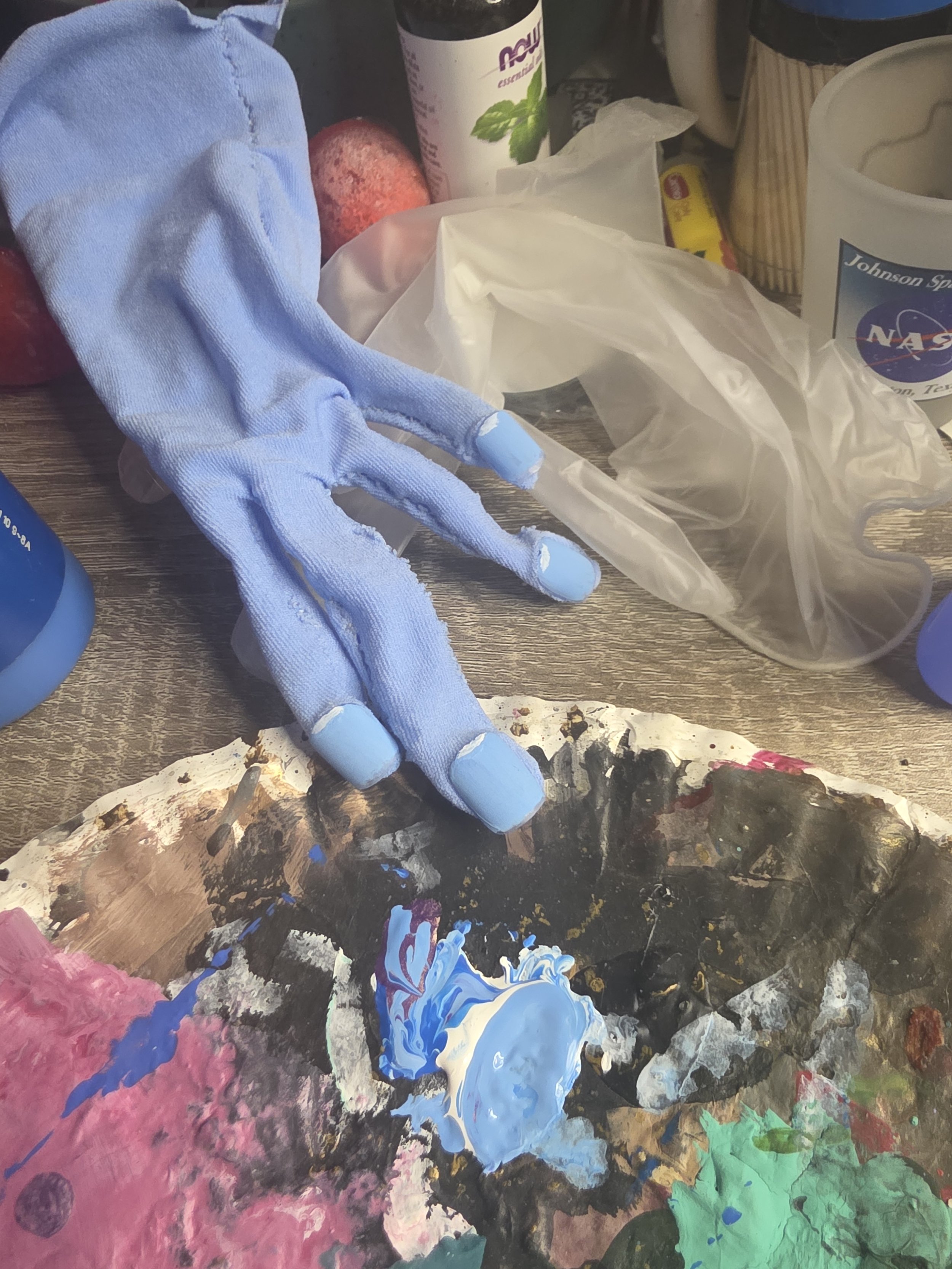 hand in a glove made of pale blue tights. It looks skinny and floppy with no hand in it. Details have been painted on the nails