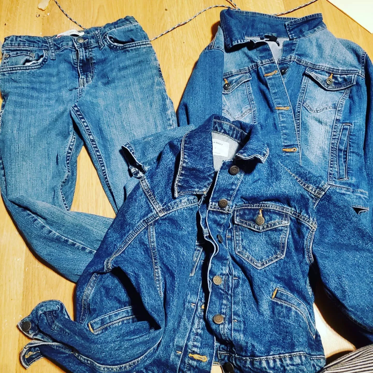 pile of thifted jeans and denim jackets