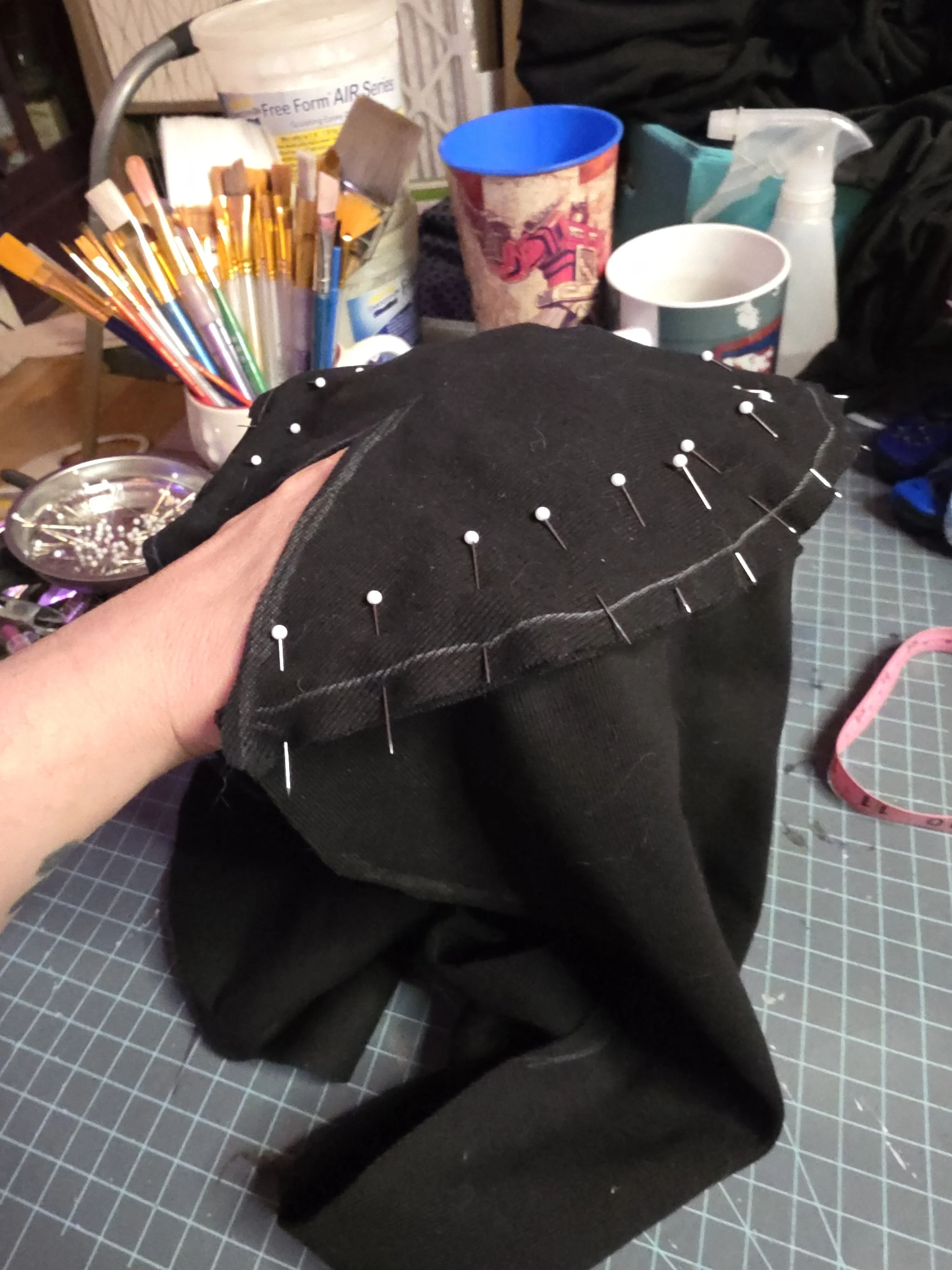 Black fabric pinned together to be sewn into a ninja's hood