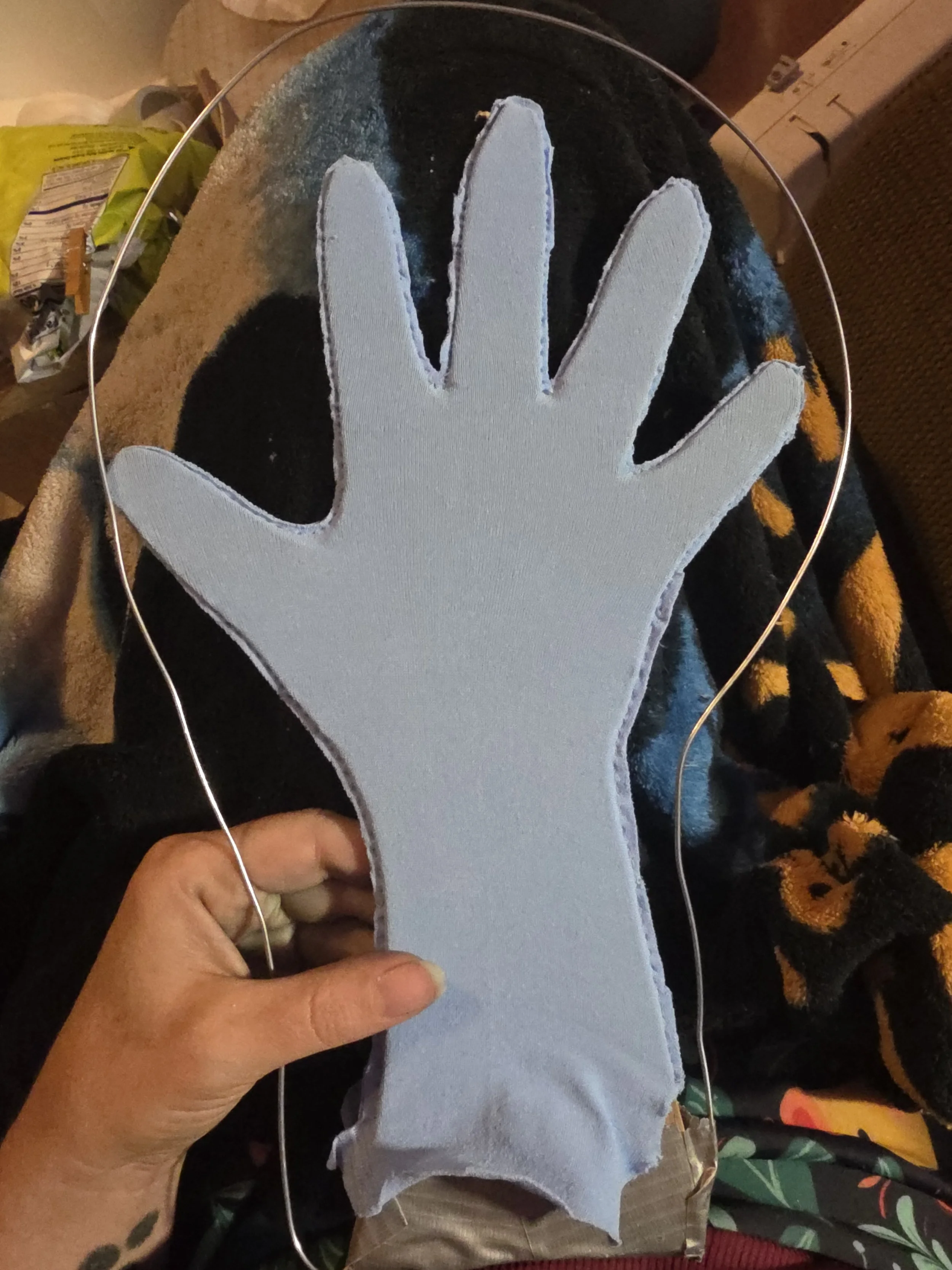 blue tights stitched around a cardboard hand shape to make a glove. 