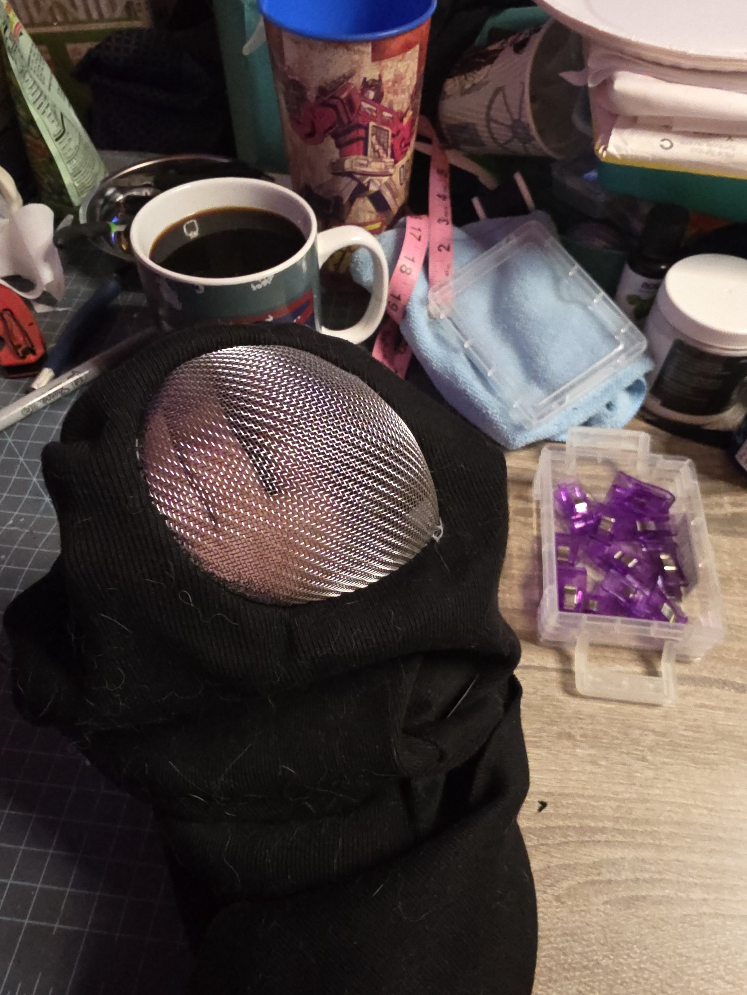 One metal screen eye cover is stitched into a black fabric ninja mask