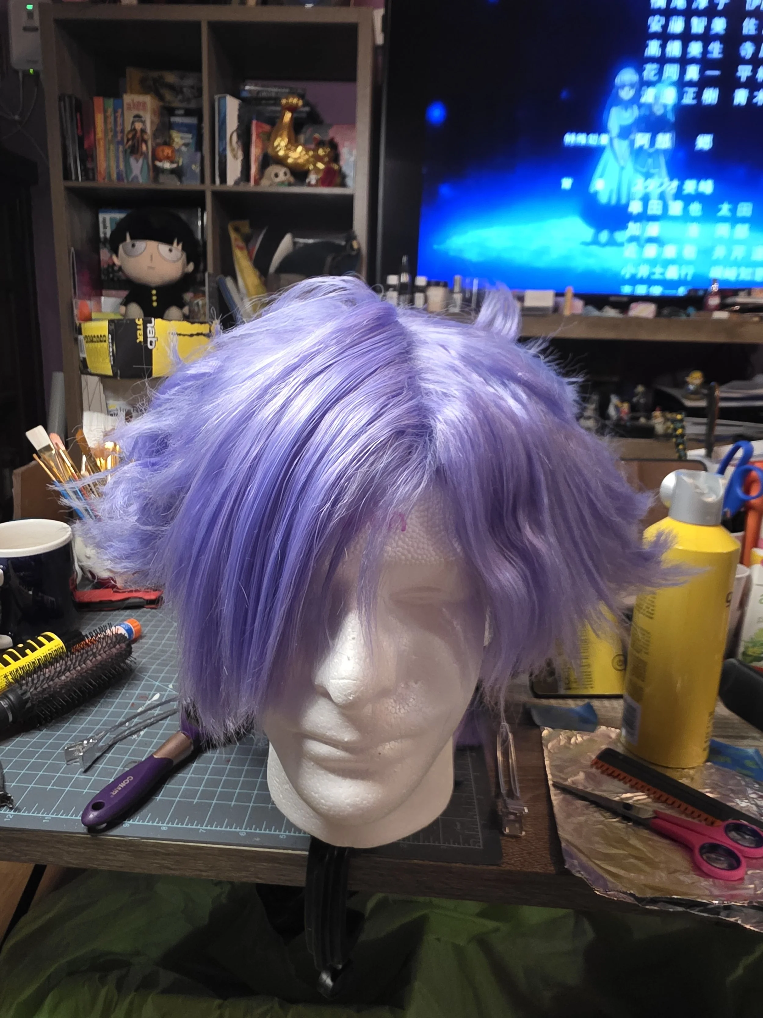 short lavender wig with long bangs combed over one eye. the sides are spiked outwards