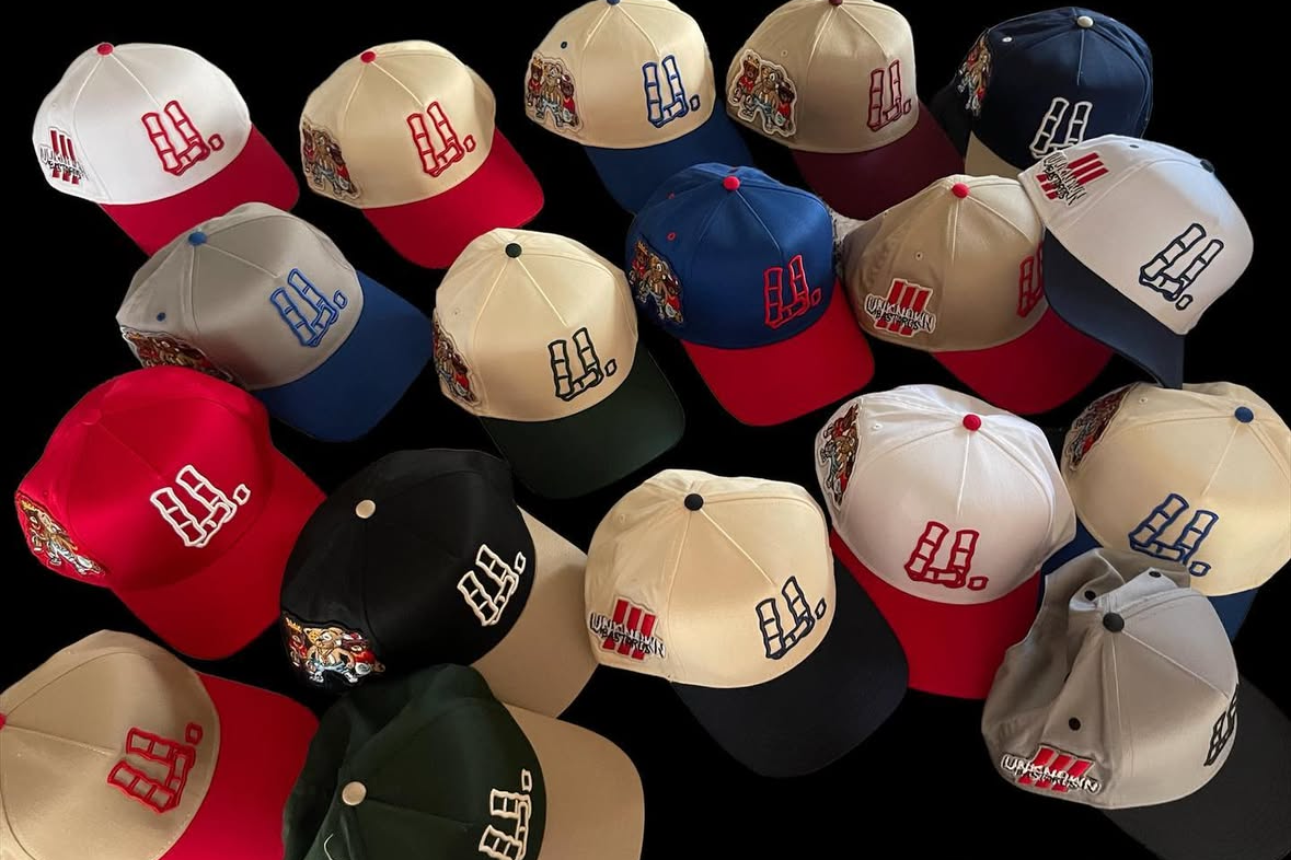 A collection of baseball caps with various color combinations, featuring embroidered logos of the Seattle Seahawks and Jacksonville Jaguars, spread out on a black surface.