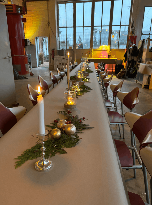 Eine dekorative Tafel mit Kerzen und Gestecken für eine Weihnachtsfeier in der WerkStadt Lüneburg.