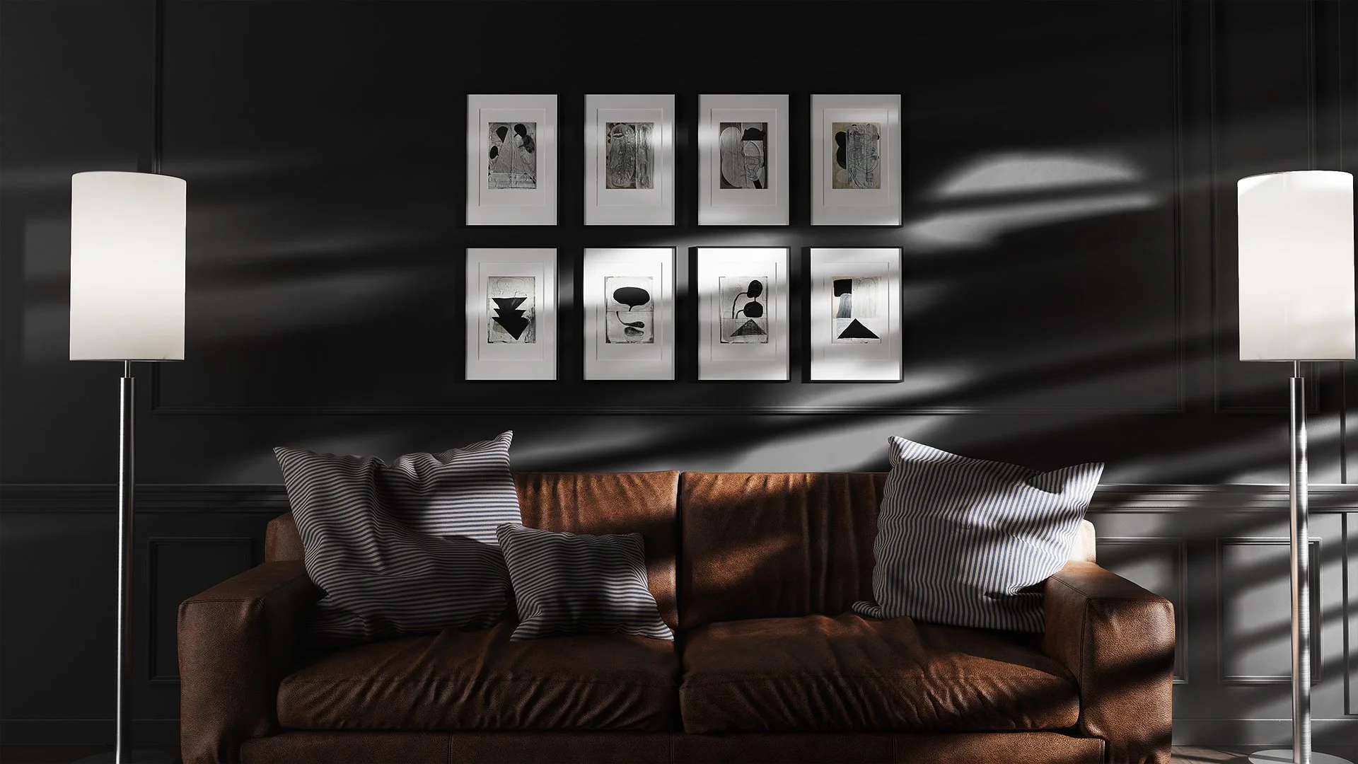A living room with a dark wall, a brown leather couch with striped pillows, two tall white floor lamps, and a wall art arrangement of nine framed abstract black and white artworks.