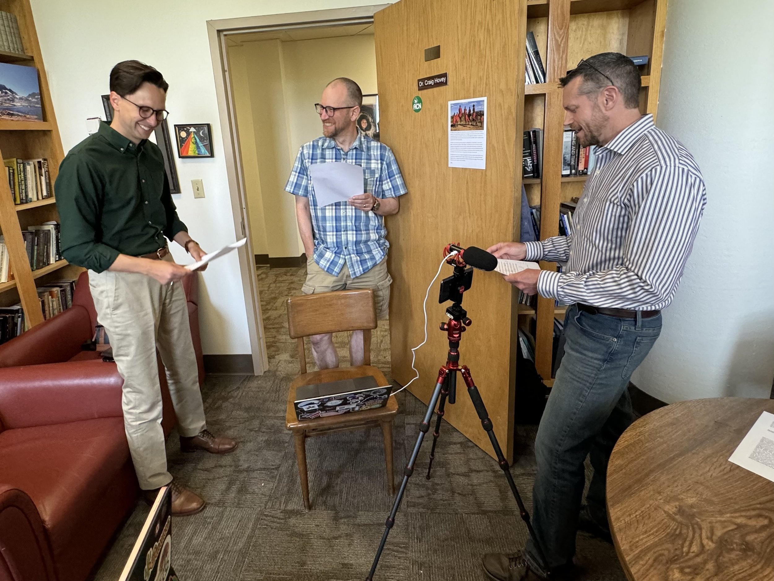 Some professors check their notes just before starting their round table discussion in one of their offices.