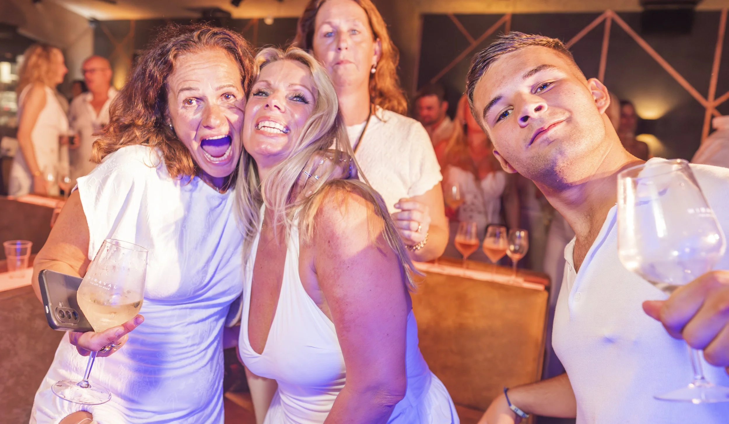 Groep mensen die feest vieren, selfie gemaakt in een bar, met wijn en op een feestvierende achtergrond.