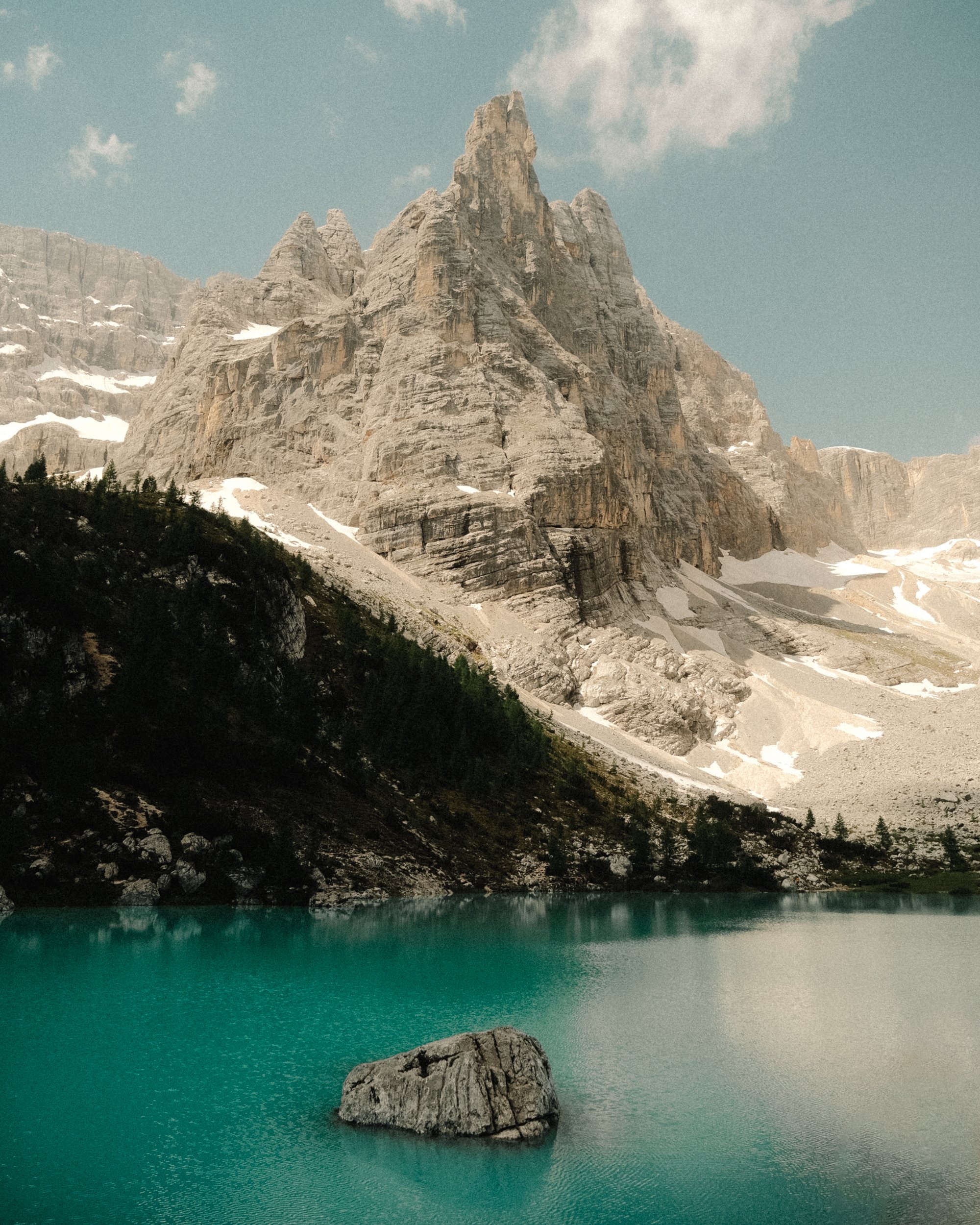 Montagne rocheuse avec sommet pointu, reflet dans un lac turquoise, forêt de conifères en contre-bas. Paysages, photo, montagne, rando, randonnée, sport, outdoor, exposition