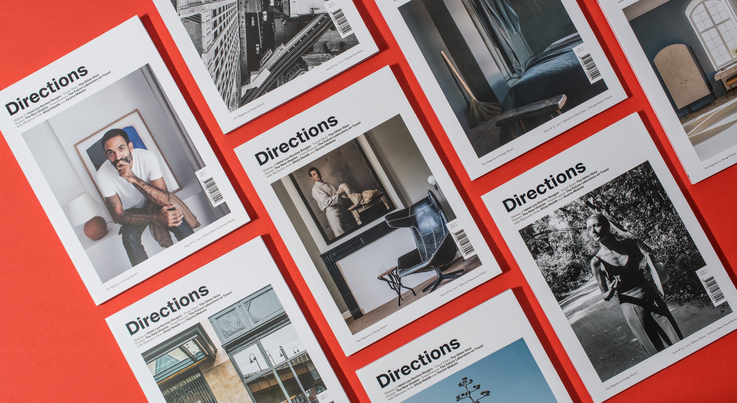 A collection of magazines called "Directions" displayed on a red surface, featuring various interior and exterior photography of architecture and lifestyle.