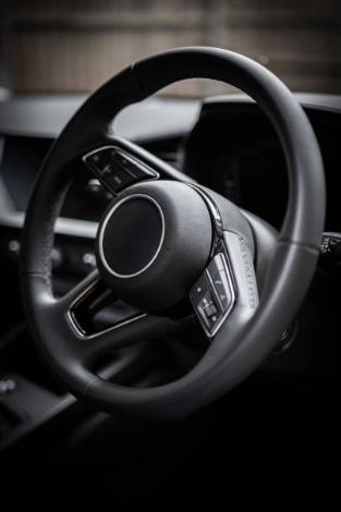 Close-up of a car steering wheel with control buttons.