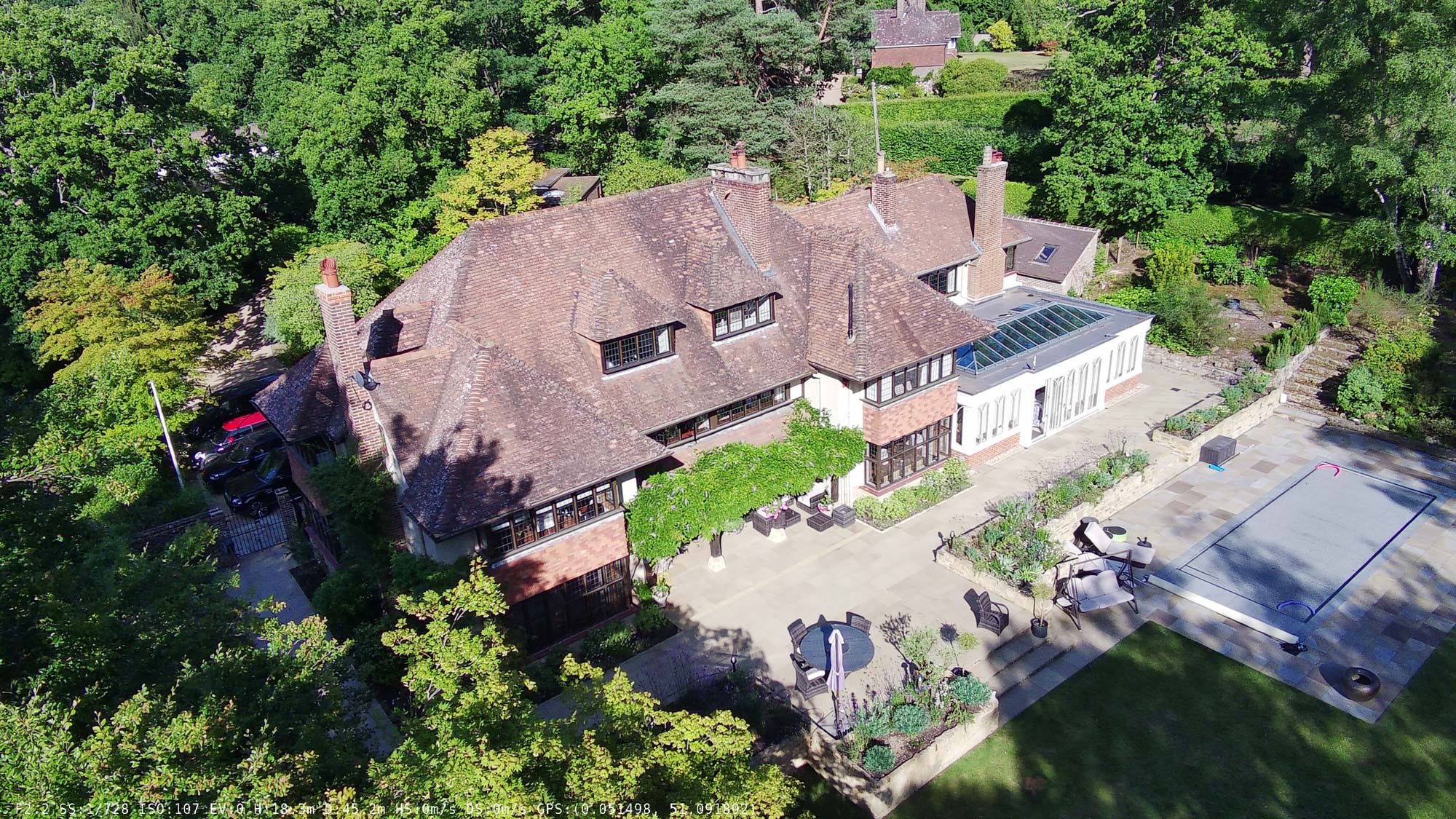 Converted barn-style home with pitched slate roof, timber details, and gravel driveway in a rural English village.
