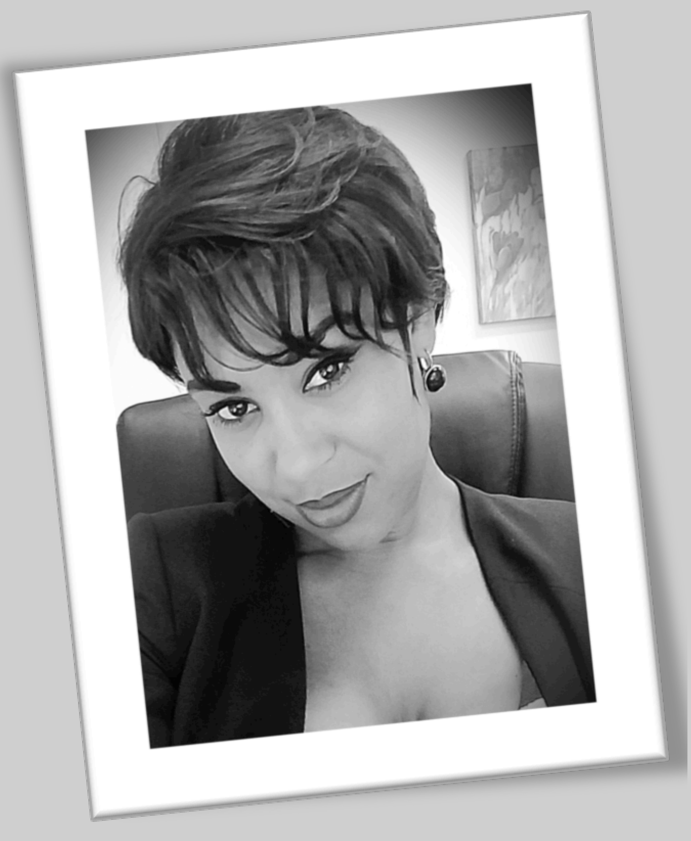 Black and white portrait of Erica Knight, founder of Focus PR Group, with short textured hair, wearing earrings and a blazer, seated in a leather chair, representing strategic marketing, public relations, customer experie and brand strategy.