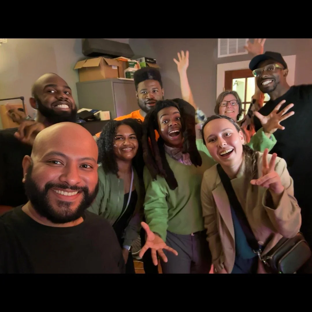 Group of diverse friends smiling and cheering in a cozy indoor setting.