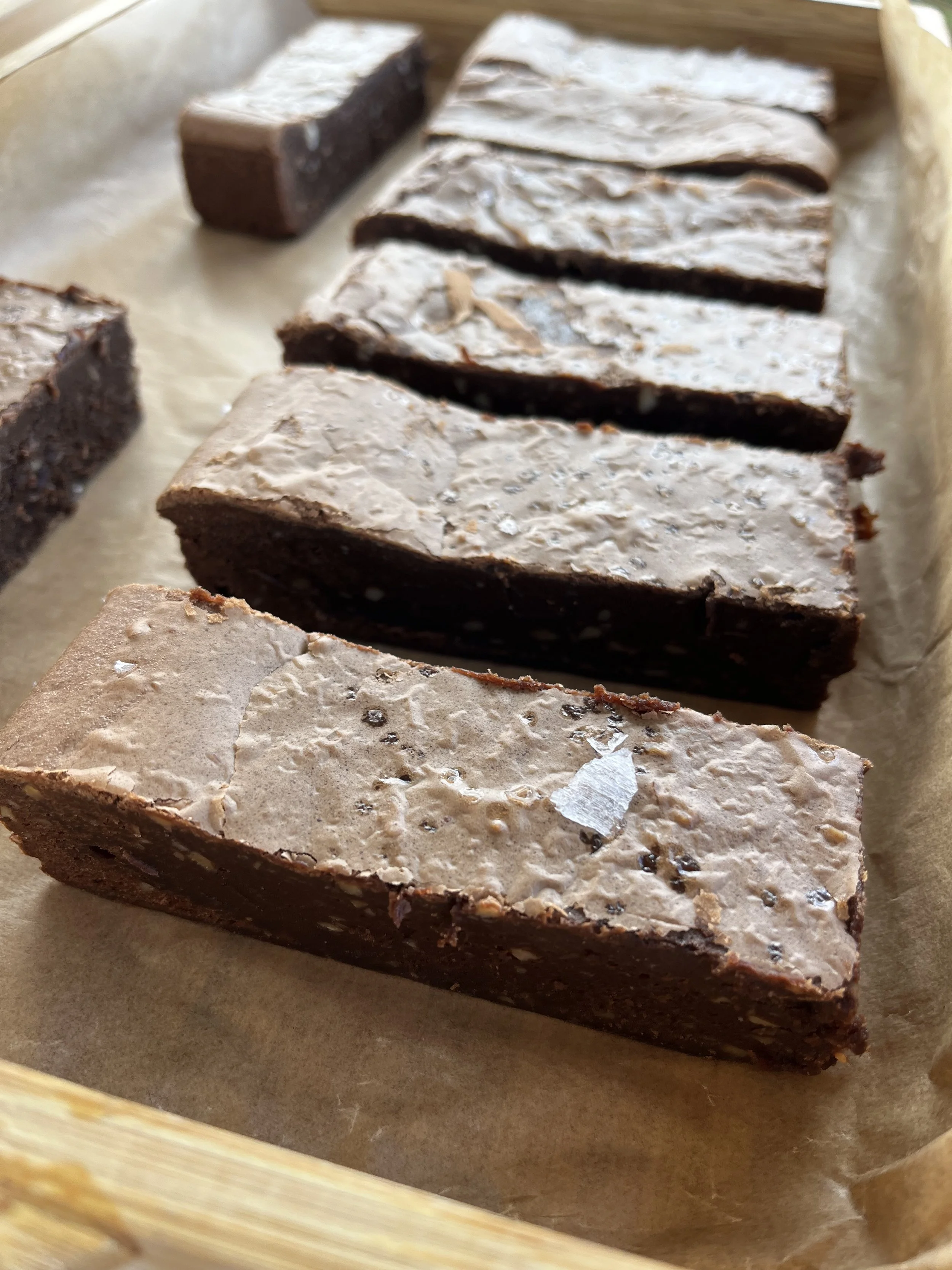 Chocolate brownies on a parchment-lined tray.