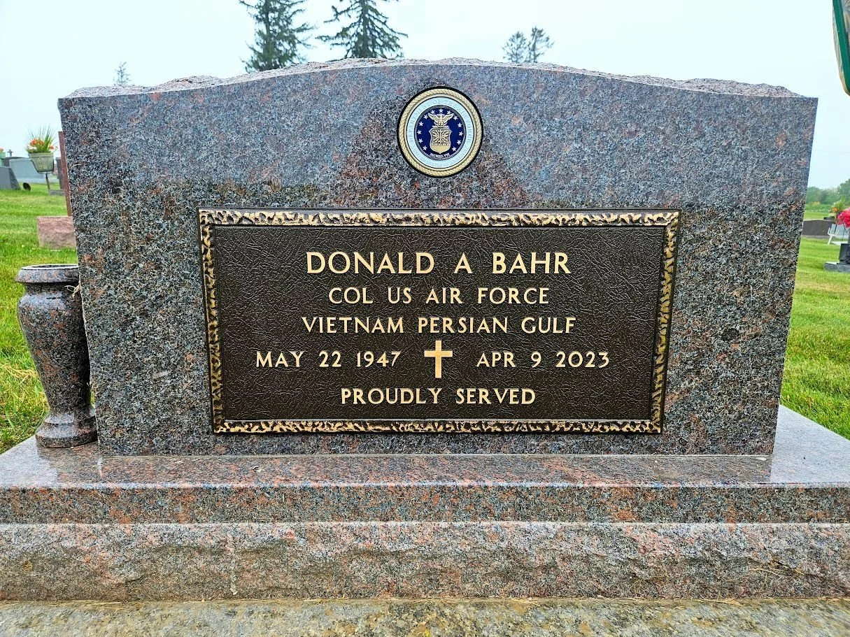 VA Bronze and Military Badge Mounted on the back of a Mahogany Granite Gravestone