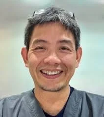 Smiling man with short dark hair.
