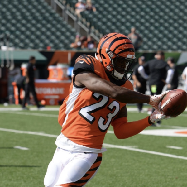 A football player from the Cincinnati Bengals catching a football on the field during a game.