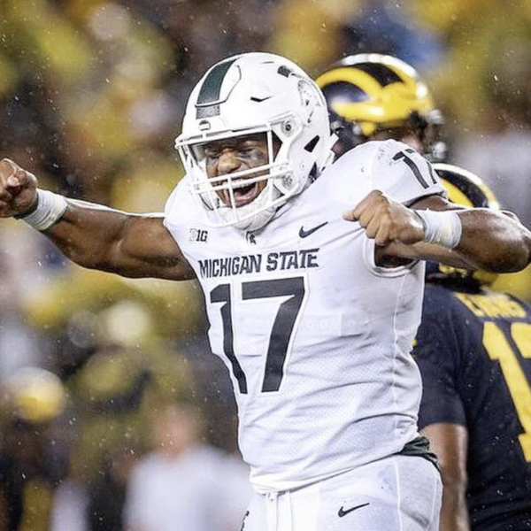 Michigan State football player wearing number 17, celebrating with arms raised during a game in rainy weather.