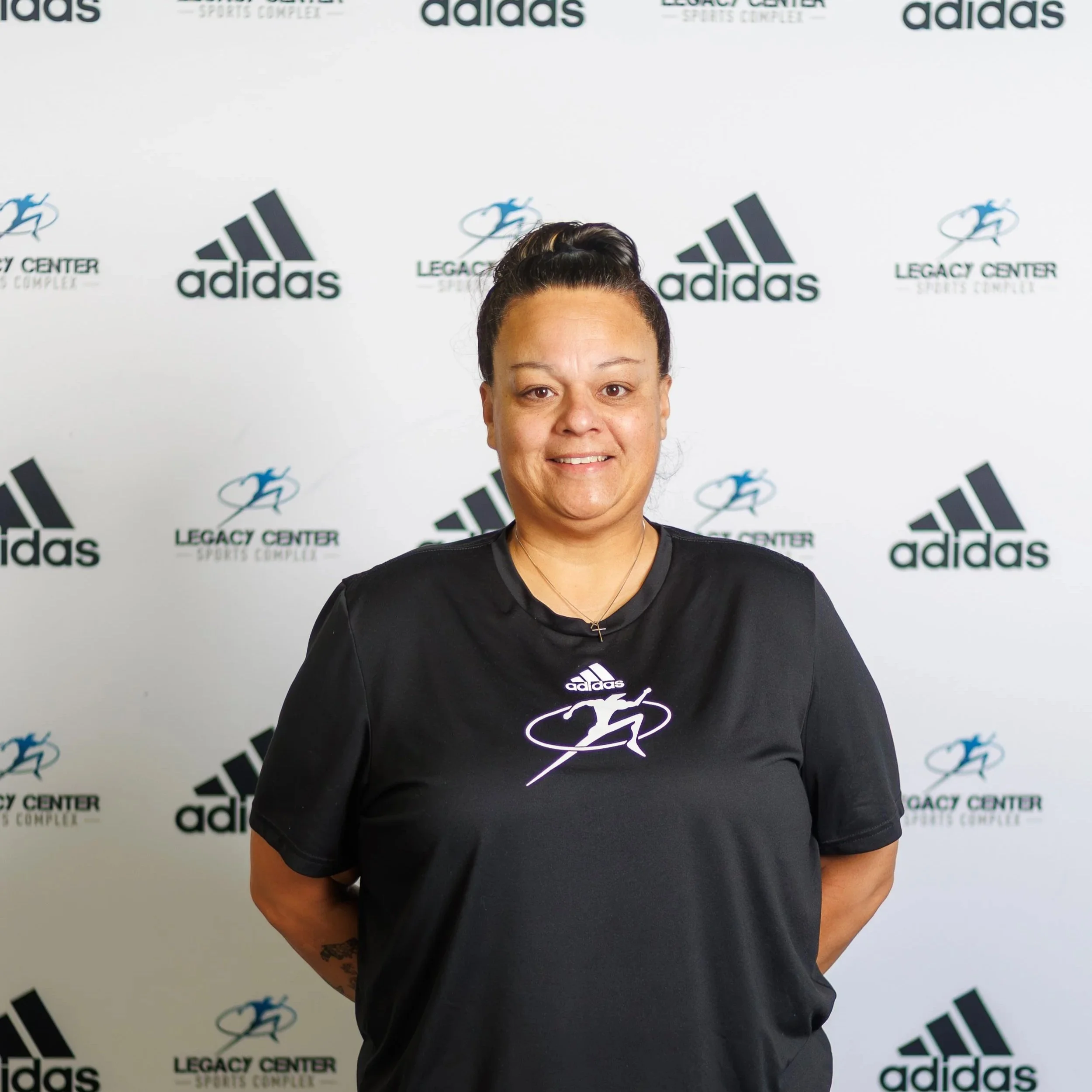 Softball coach speaking to two young players on the field during a game.