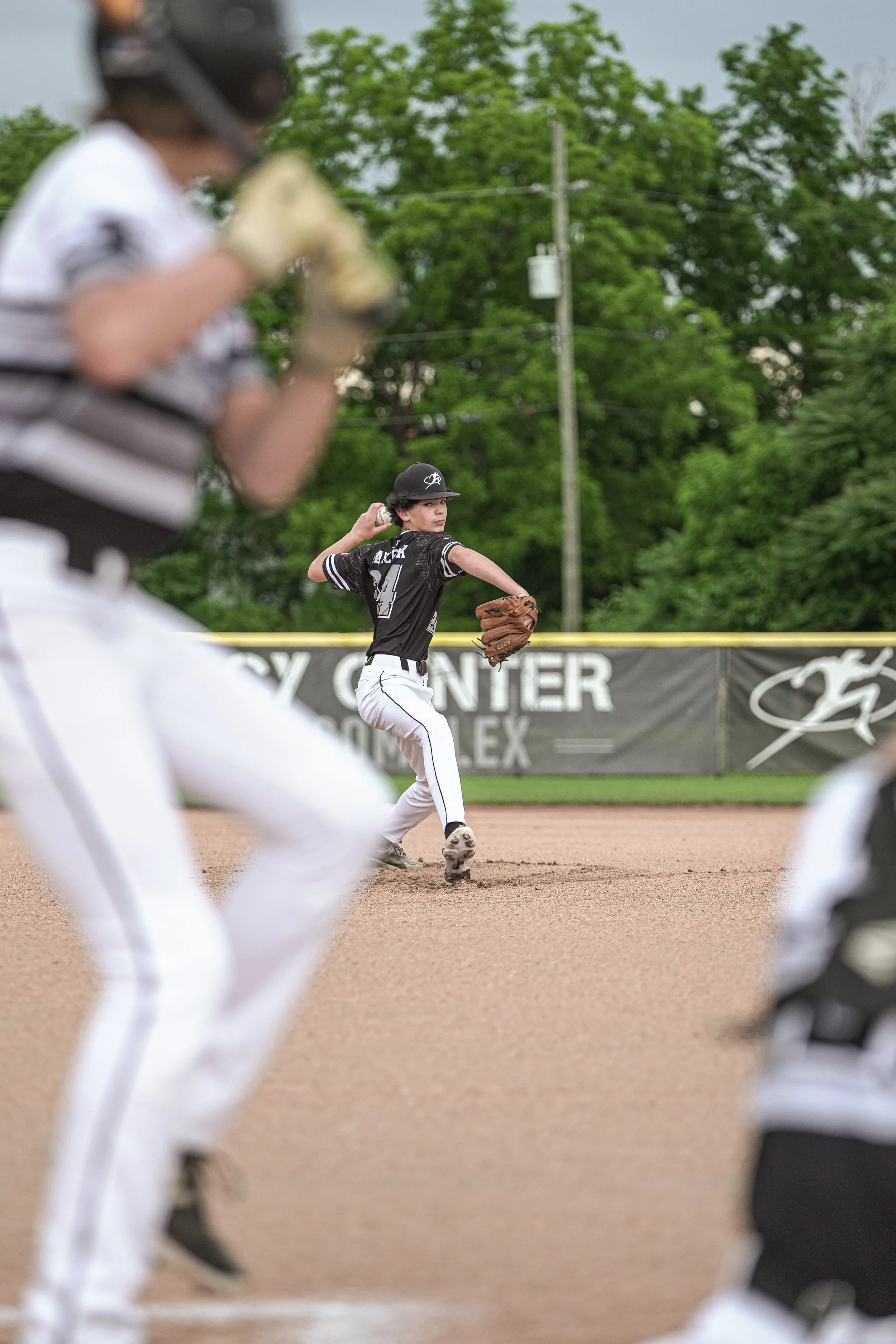 Young baseball player in a uniform catching a ball with his glove during a game.