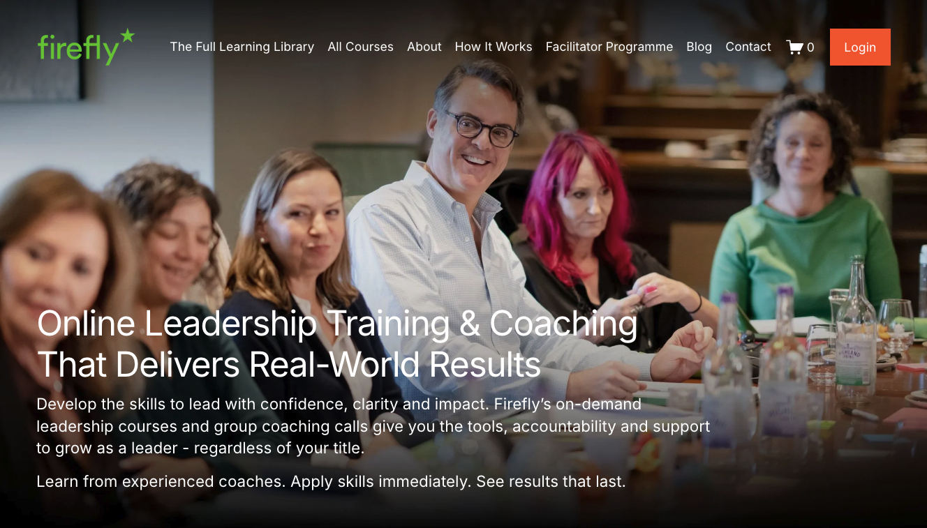 A group of diverse adults sitting around a table during a virtual leadership training session, smiling and engaged.