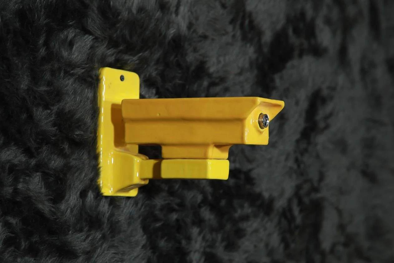 A yellow ceramic CCTV camera, bracketed and mounted on a black furry surface.