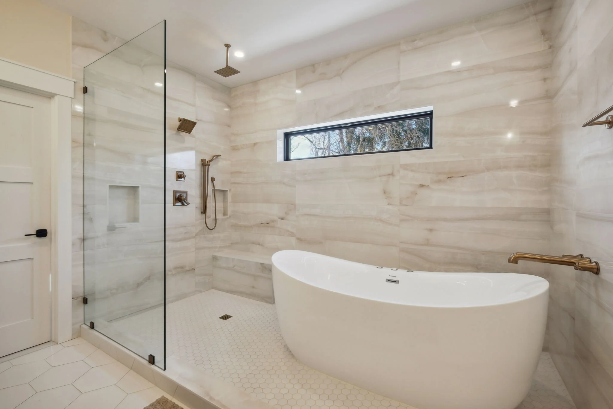 Wet room with hexagon tiles in varying sizes for flooring and a porcelain wall tile 