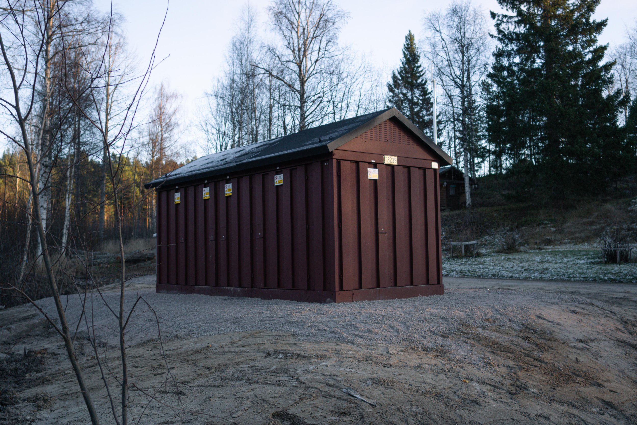Röd nätstation med frost på taket.