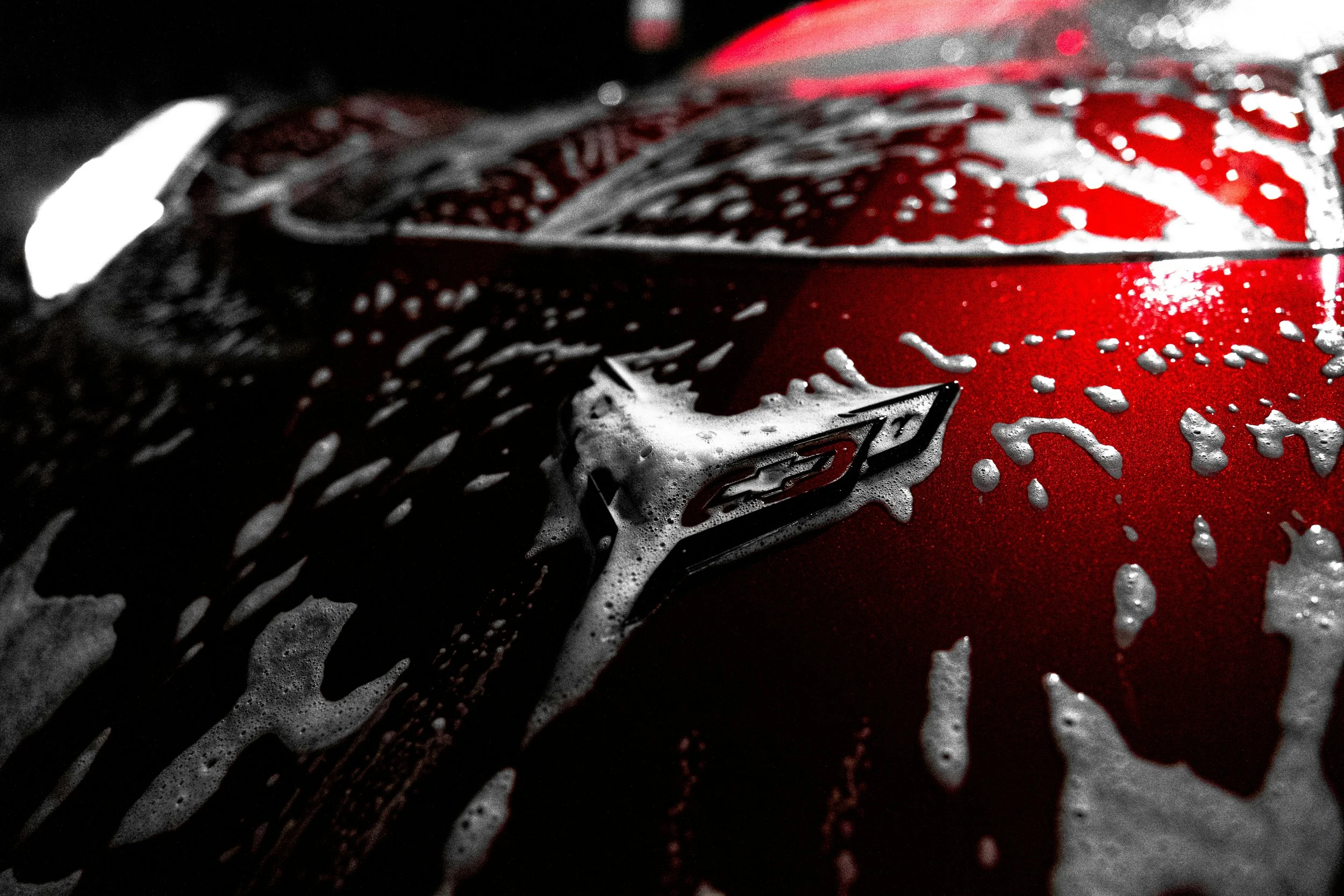 Close-up of a red soda can with foam and water droplets on its surface.