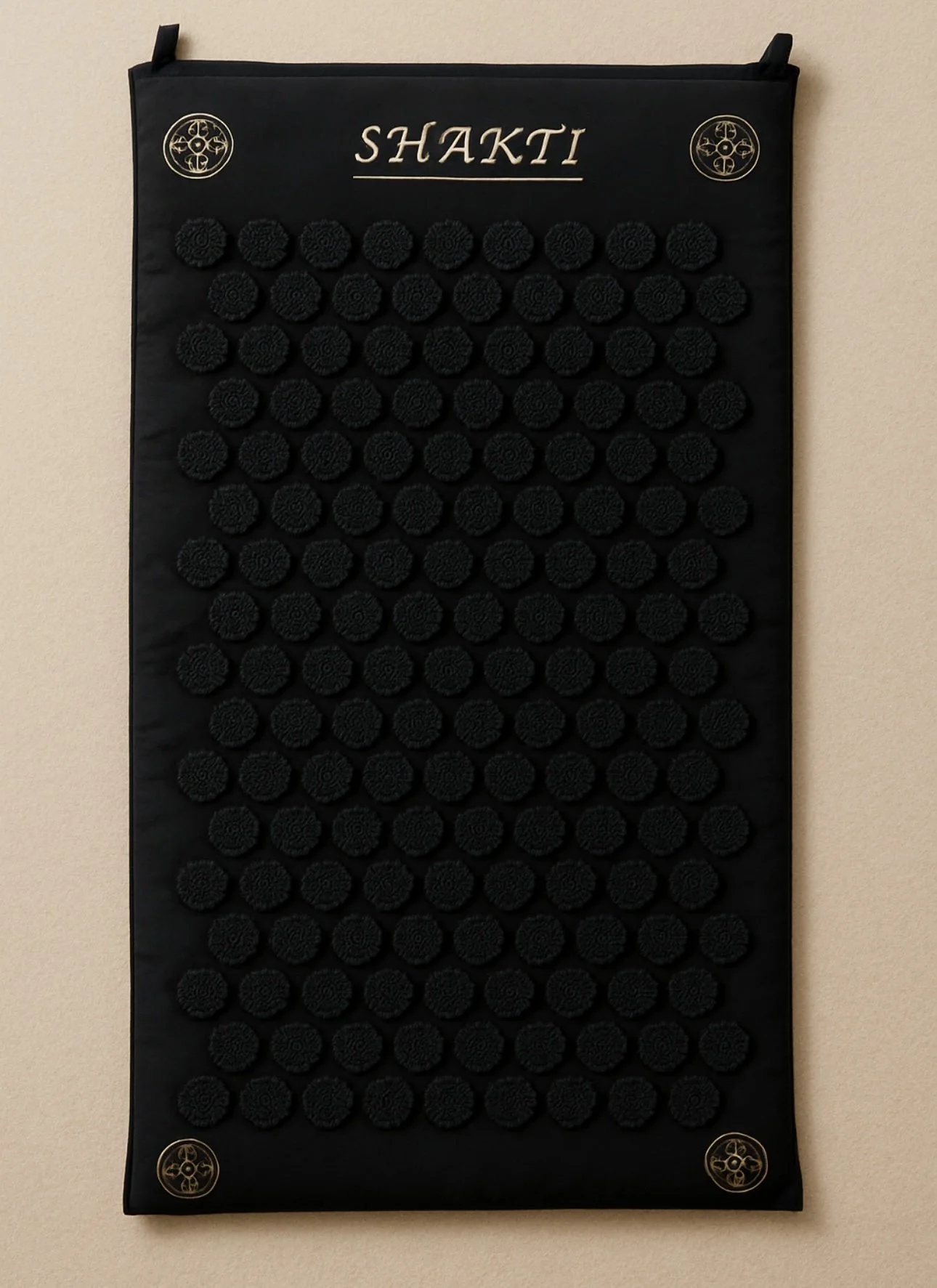 Black acupressure mat with evenly spaced black pressure points arranged in a grid