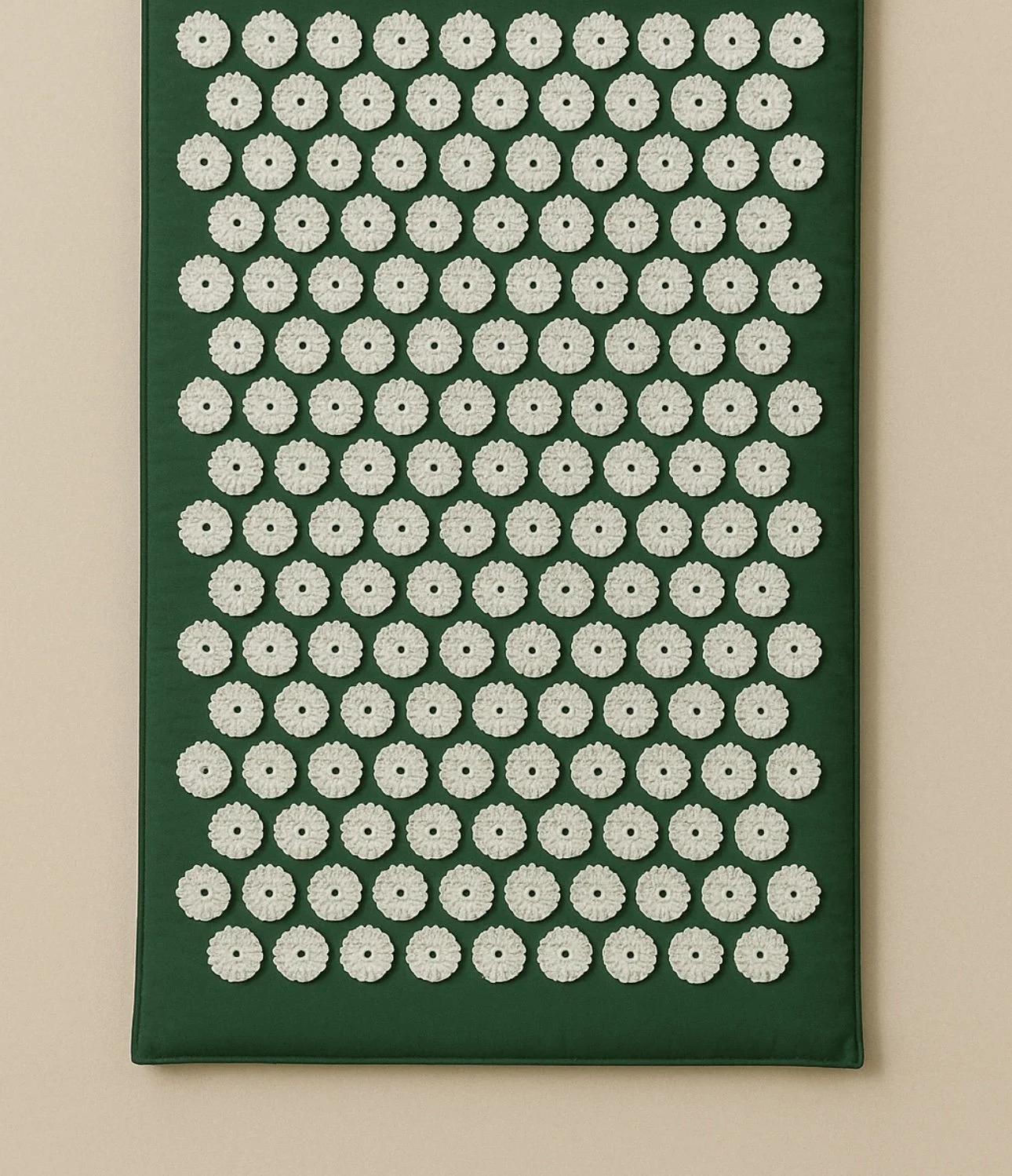 Green acupressure mat with evenly spaced white pressure points arranged in a grid.