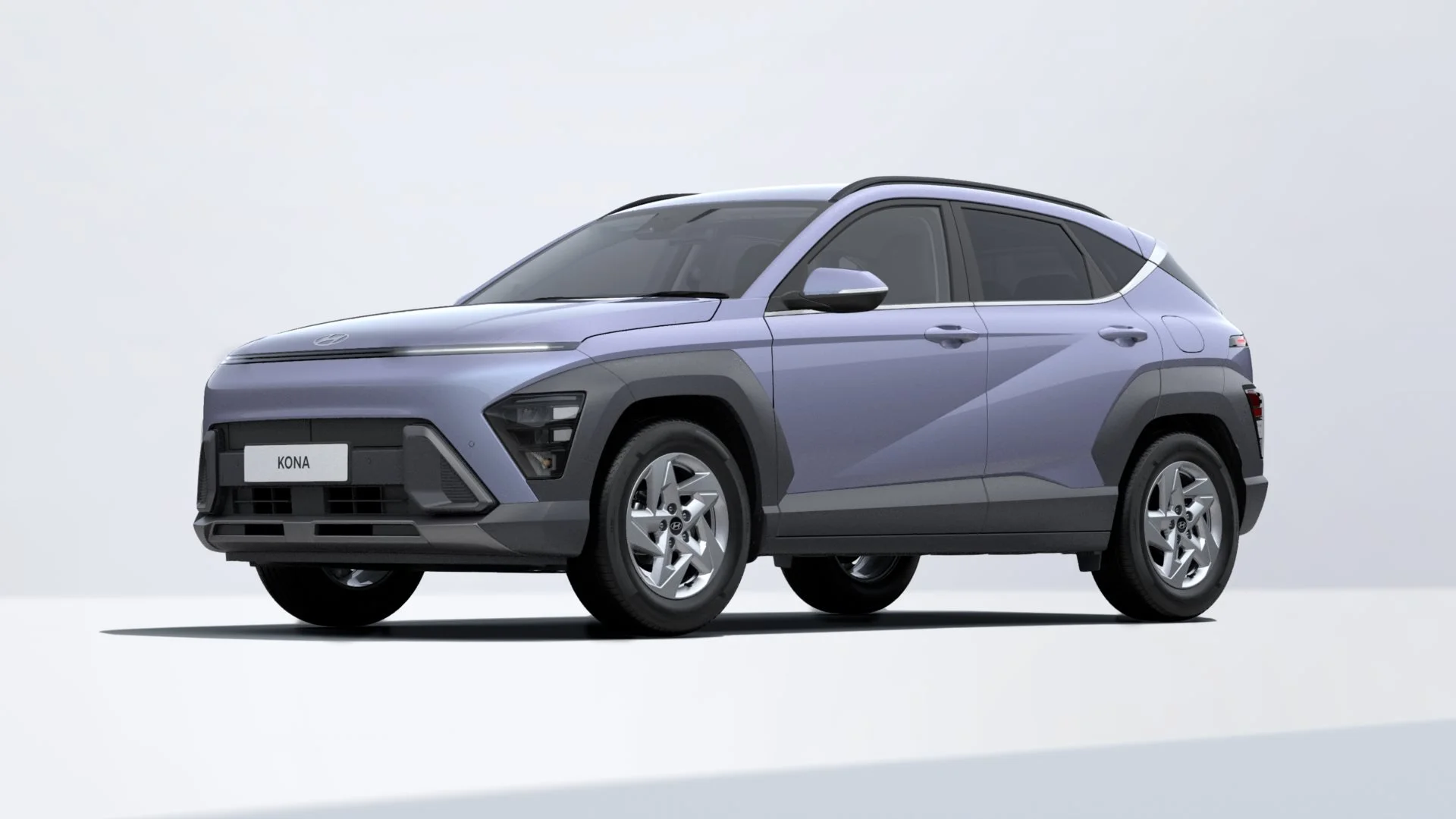 A silver compact SUV with modern design, black accents, and a Hyundai logo on the front. The vehicle has a sleek, aerodynamic shape and is parked indoors against a plain white background.