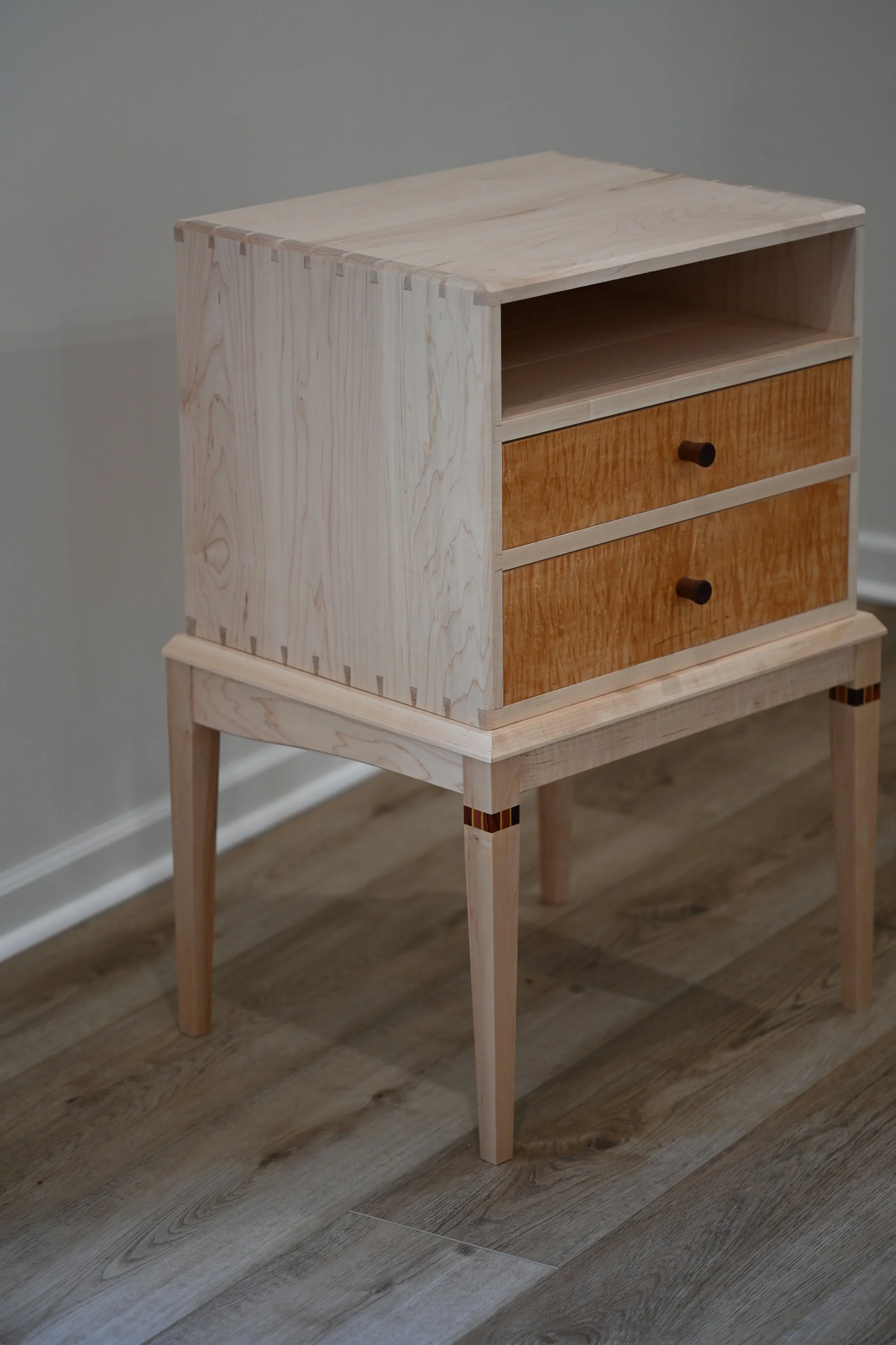 A nightstand with two drawers and an open shelf. Primary wood is maple.